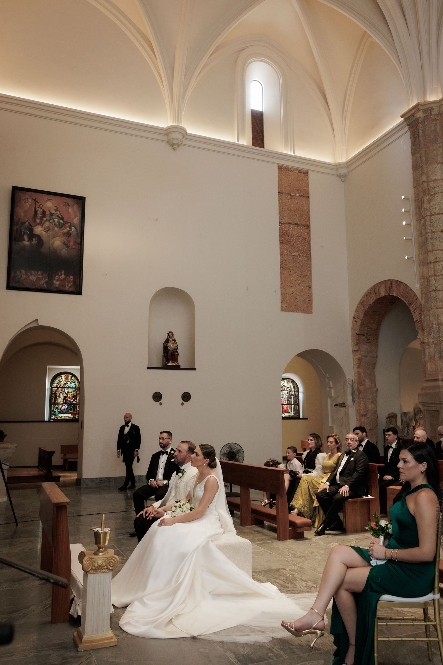 Wedding ceremony in a historic church interior with vaulted ceilings and elegant architectural details.