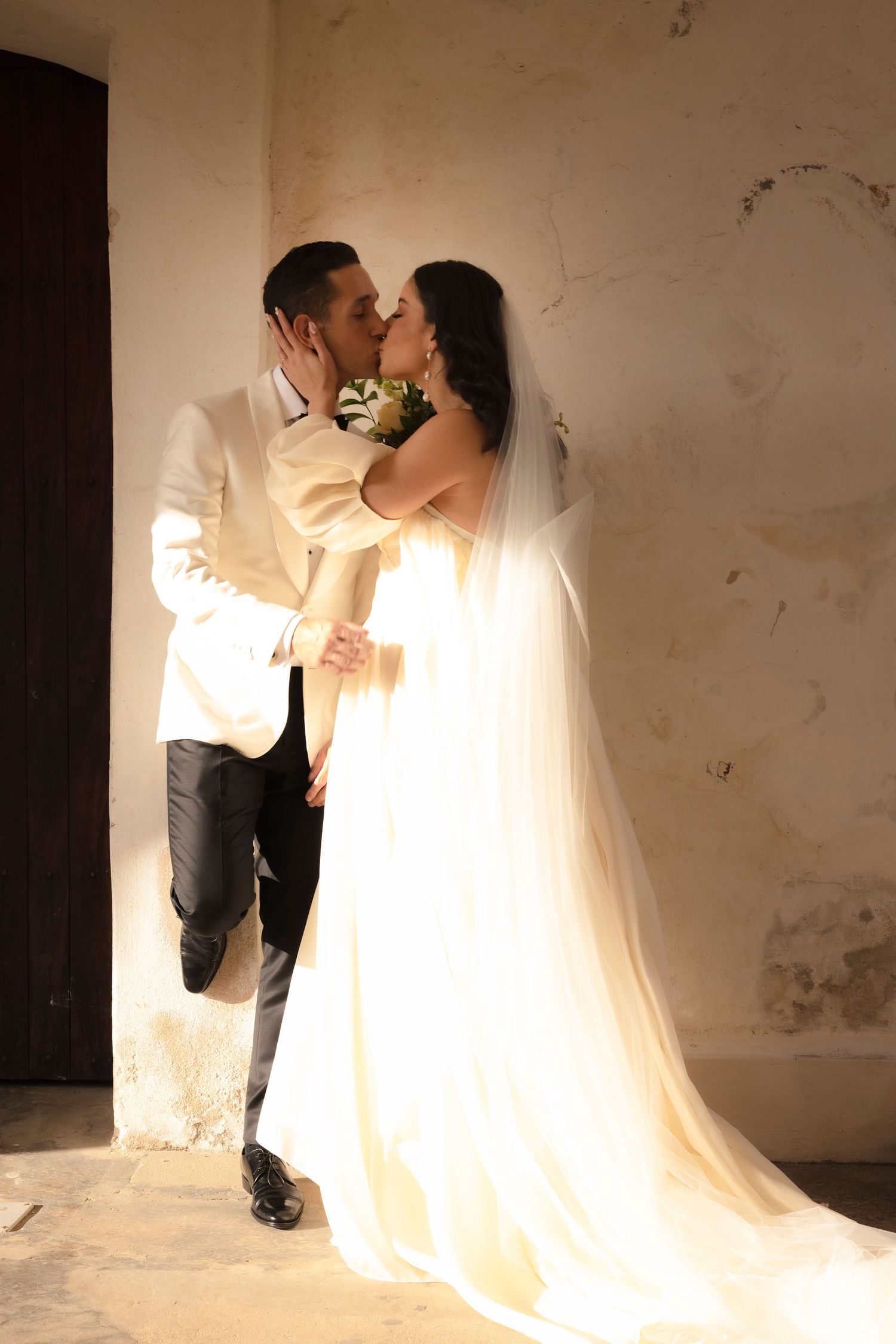 Intimate wedding portraits with soft lighting against white walls showing tender moments.