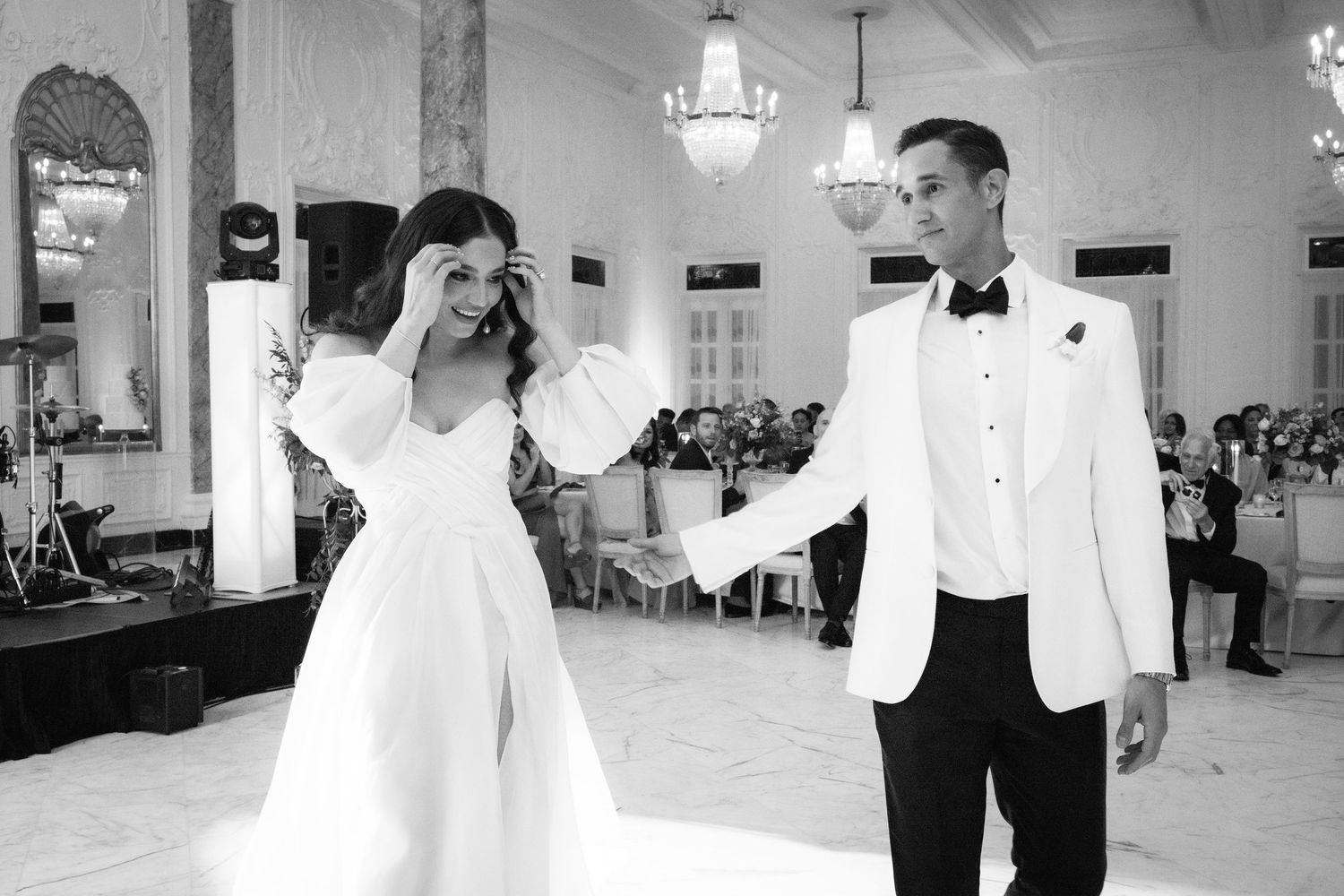Black and white photo of a playful moment during a wedding dance.