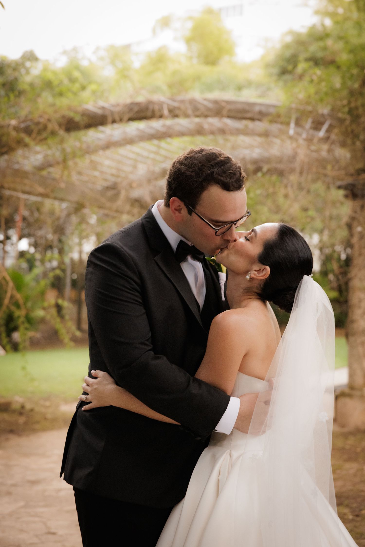 Romantic outdoor wedding portraits among trees at golden hour.