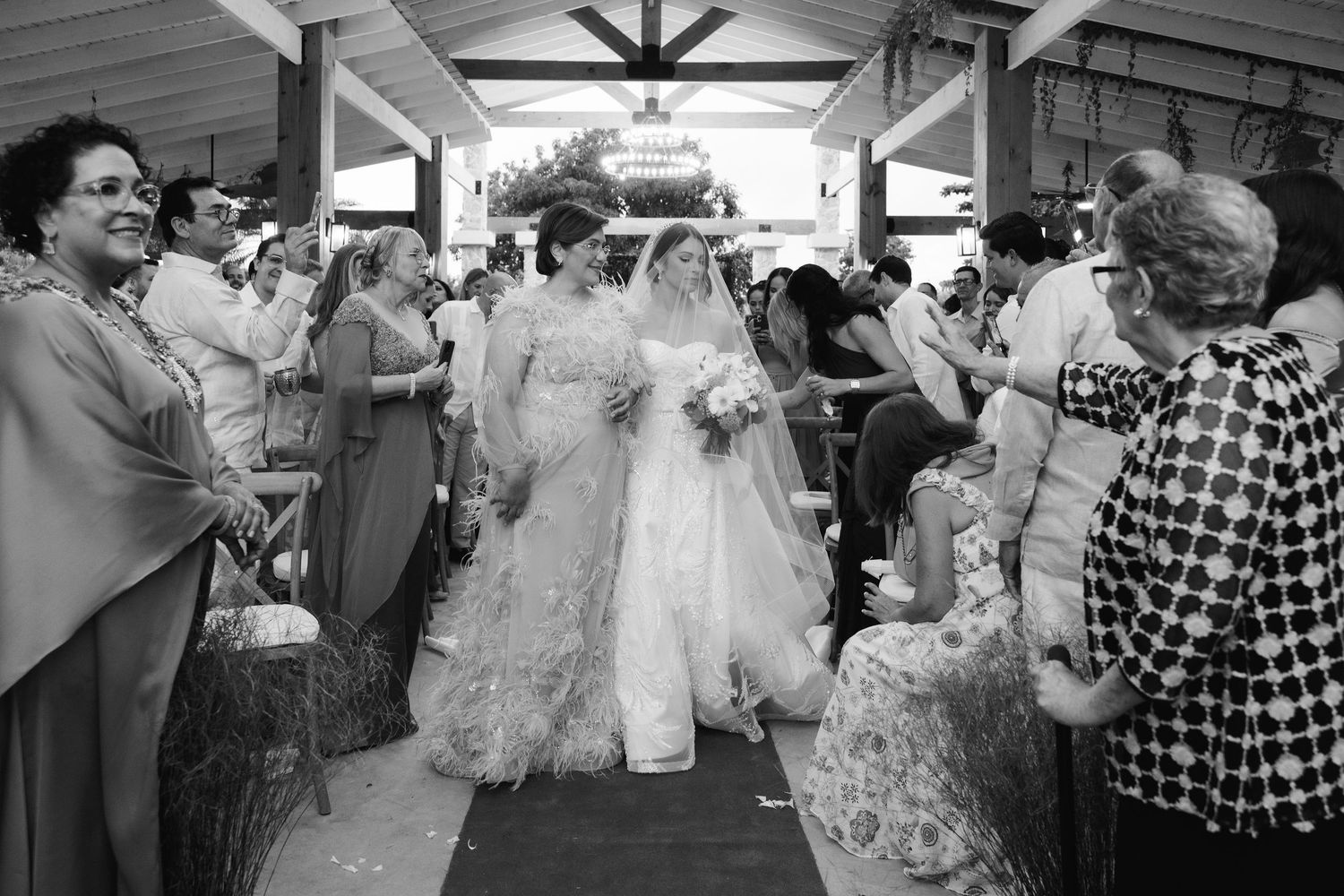 A series of black and white wedding photographs showing couples and guests celebrating at a reception venue.