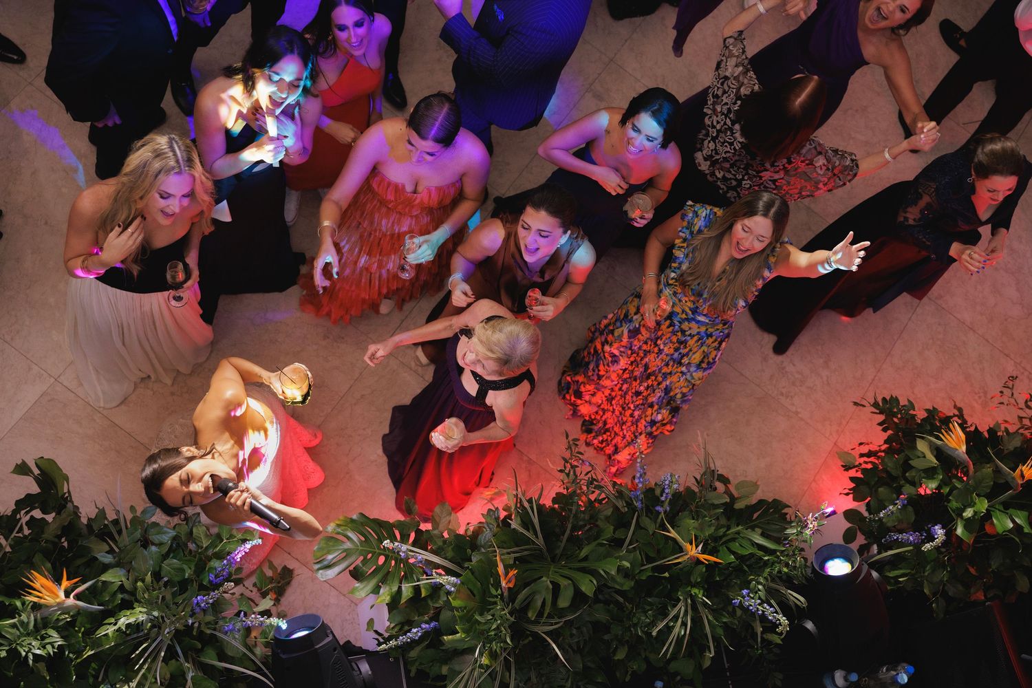 Overhead view of wedding guests dancing and celebrating on a lively dance floor.