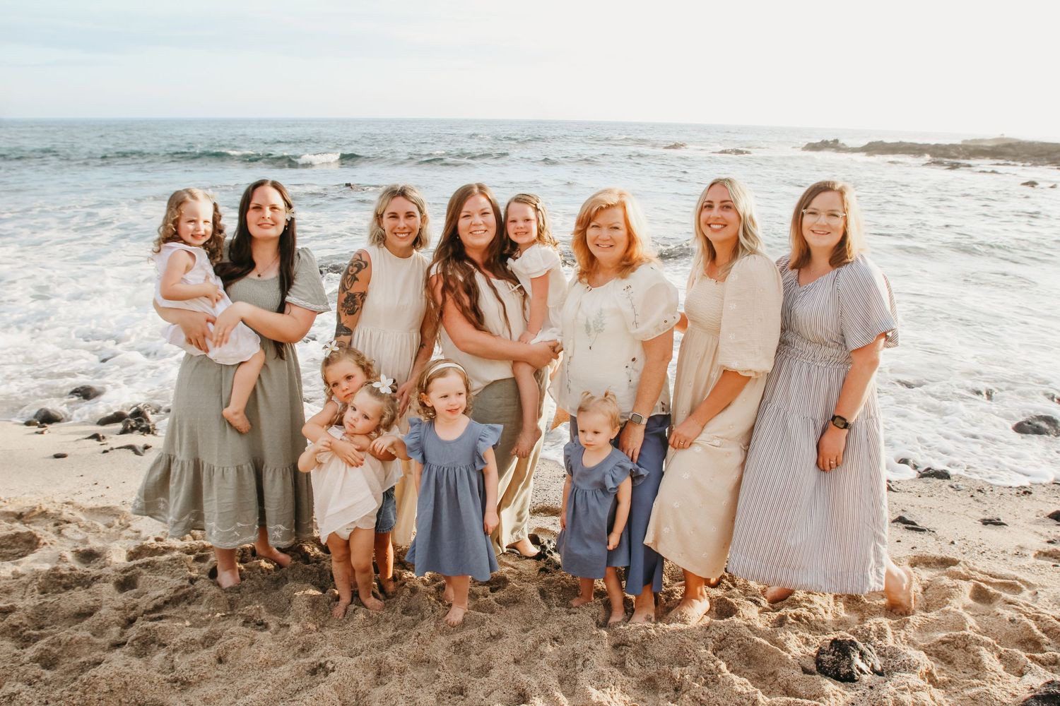Small group of six women with children from large family of 18 during sunset beach session in Kona Hawaii