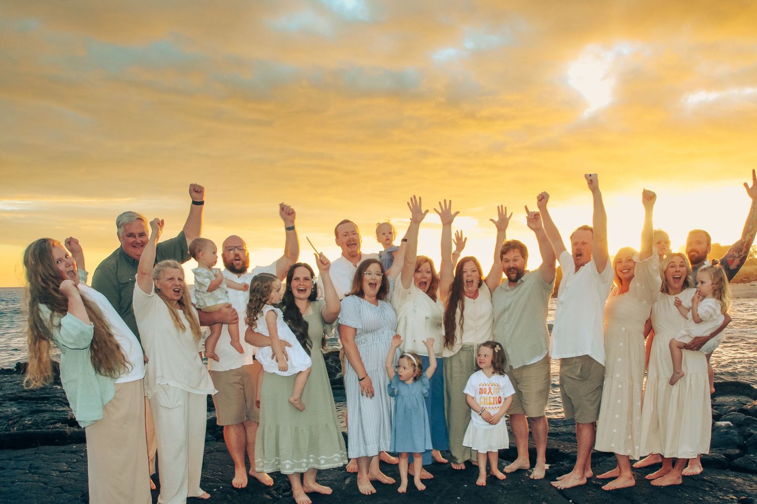 Family of 18 celebrating a child being cancer free during sunset beach session in Kona Hawaii