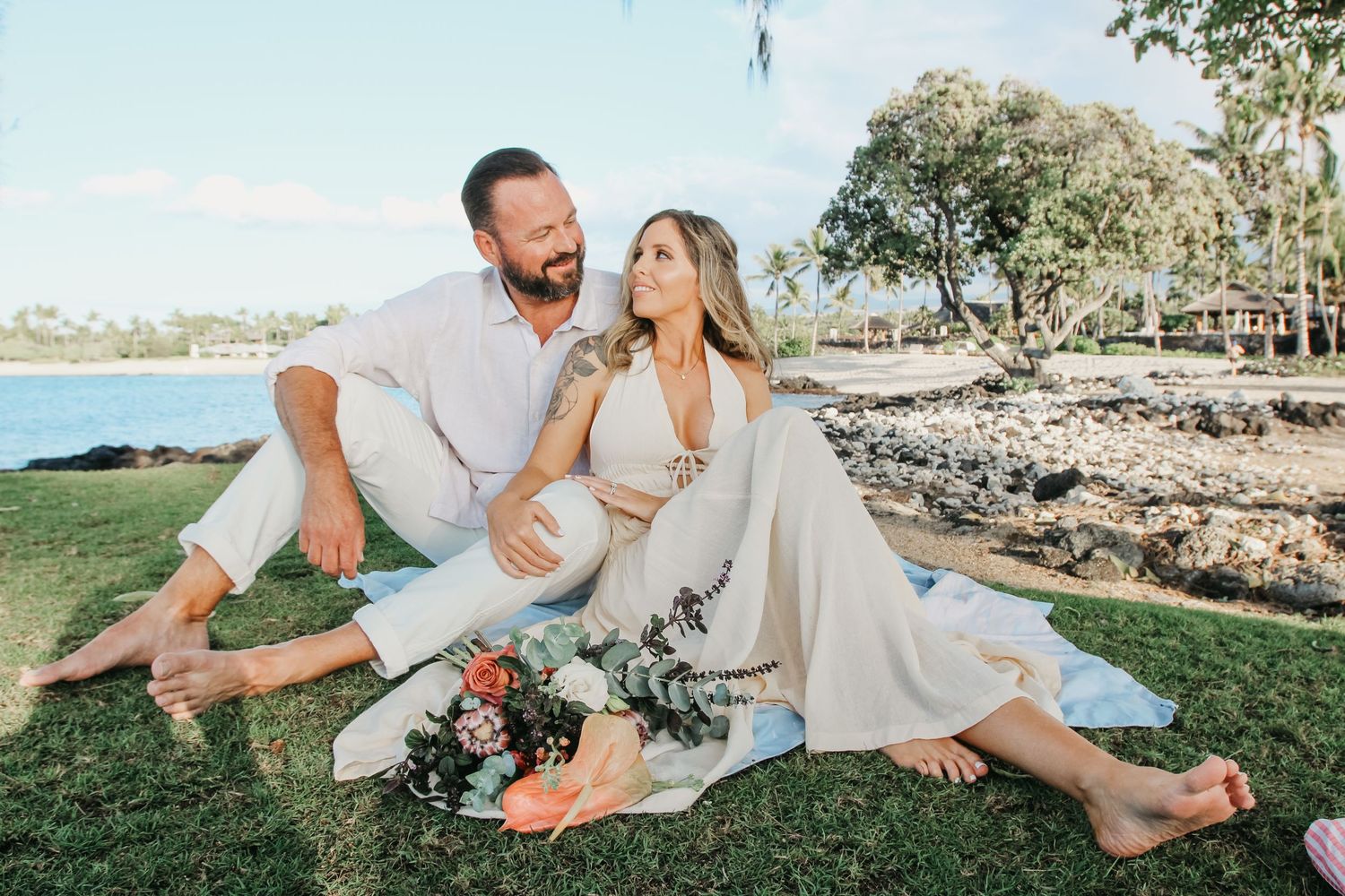 Couple sitting on grass at sunset at Kaikaua Point Beach Park Kona Hawaii