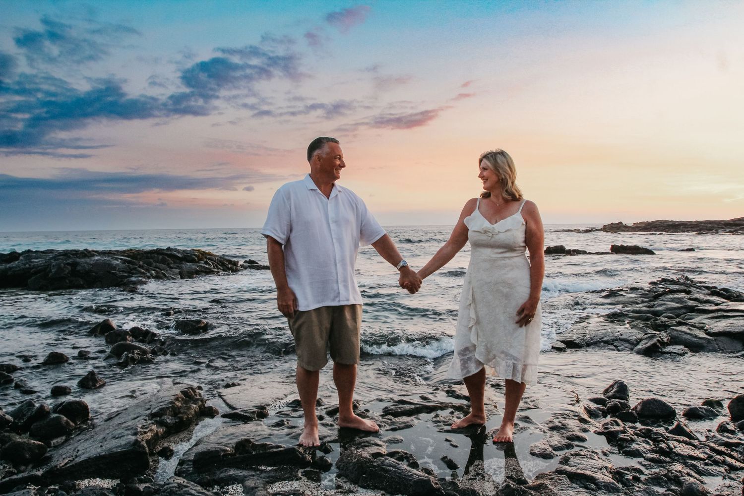 Sunset couple session on black lava rocks in Kona Hawaii with ocean views