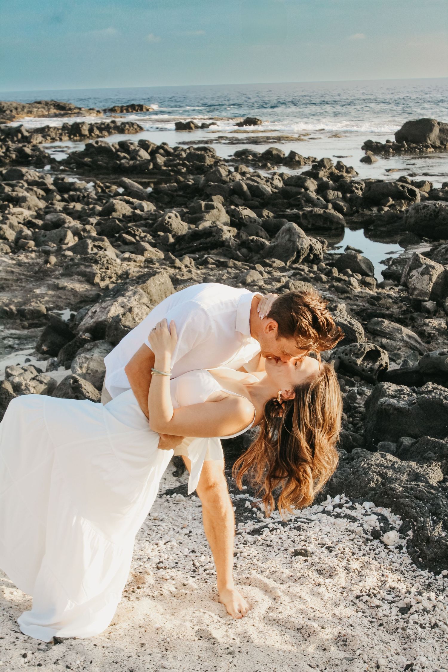 Golden hour couple dip kiss during engagement session in Kona Hawaii
