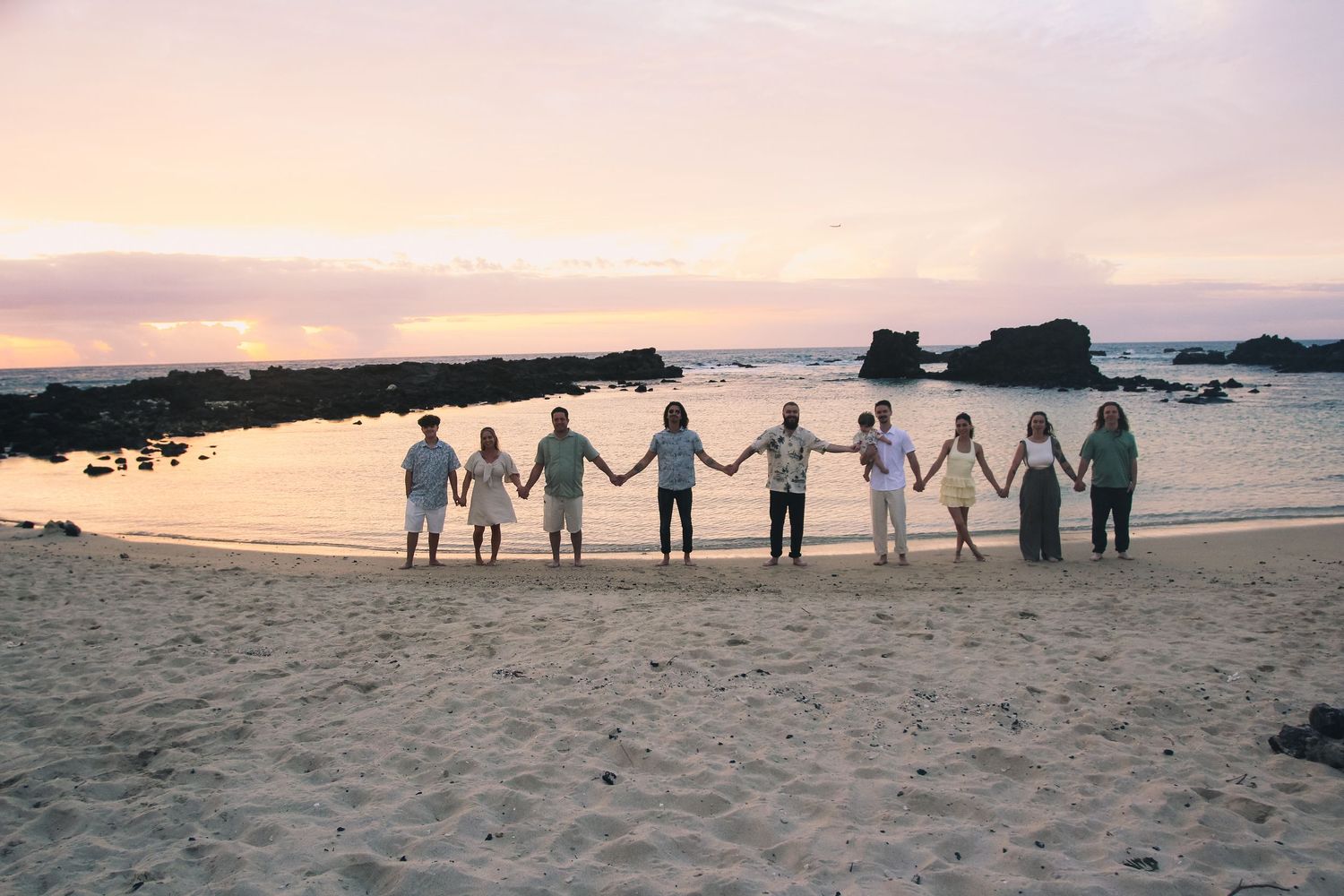 Sunset family of 10 beach session holding hands Big Island Hawaii photographer