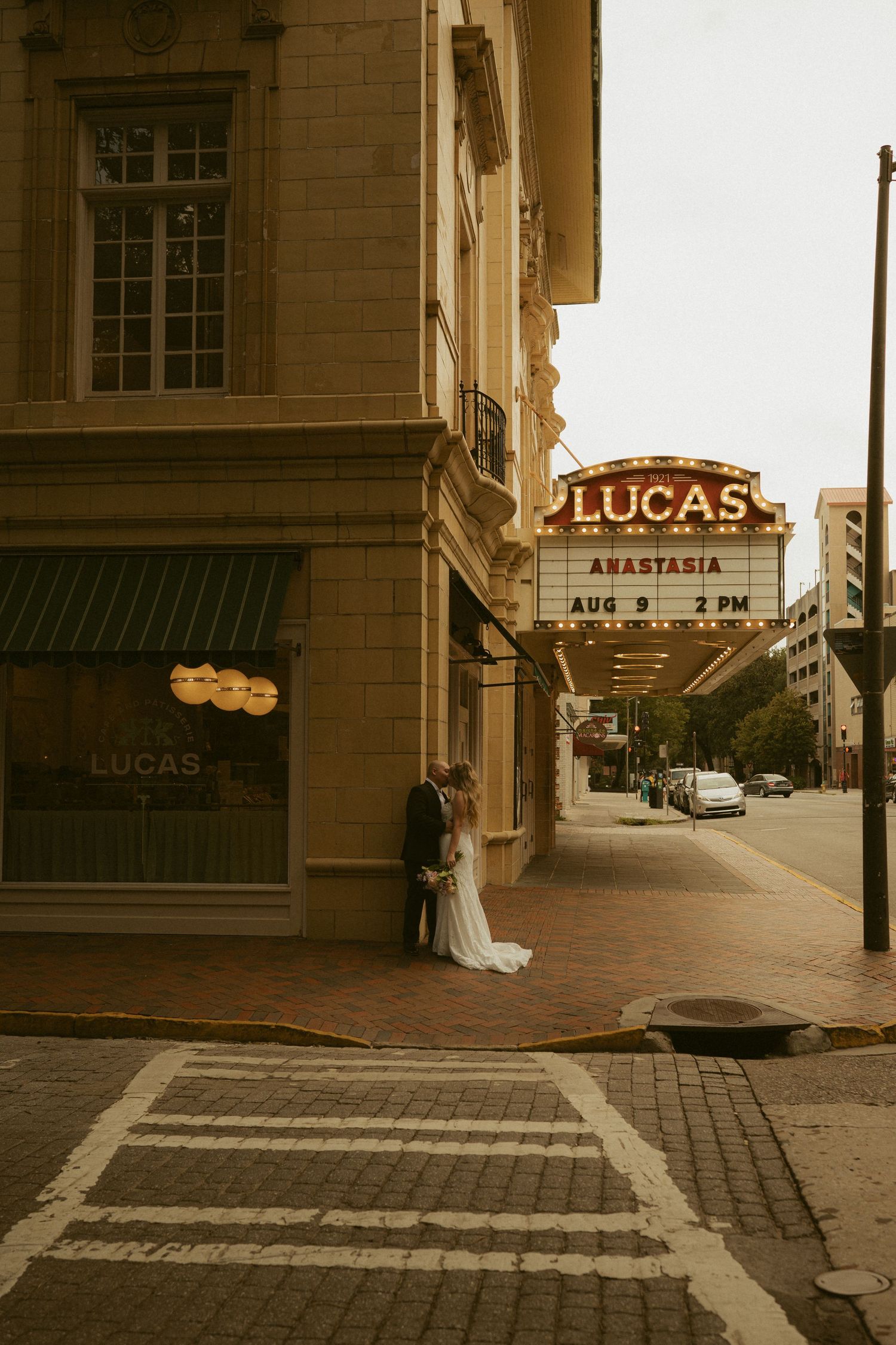 Bride and groom kissing outside the Lucas Theatre marquee displaying Anastasia on August 9 at 2PM.