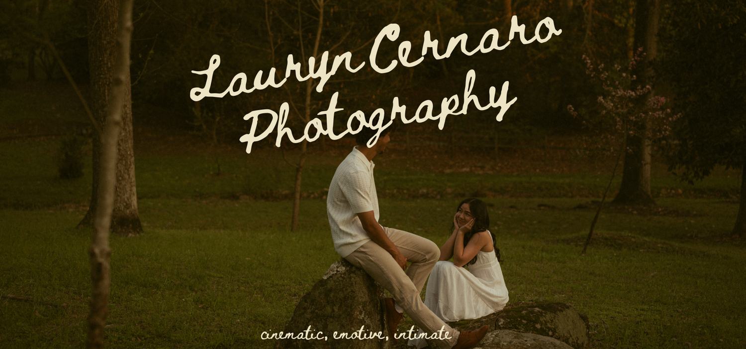 Lauryn Cernaro Photography logo over a couple sitting on rocks in a lush green park setting.