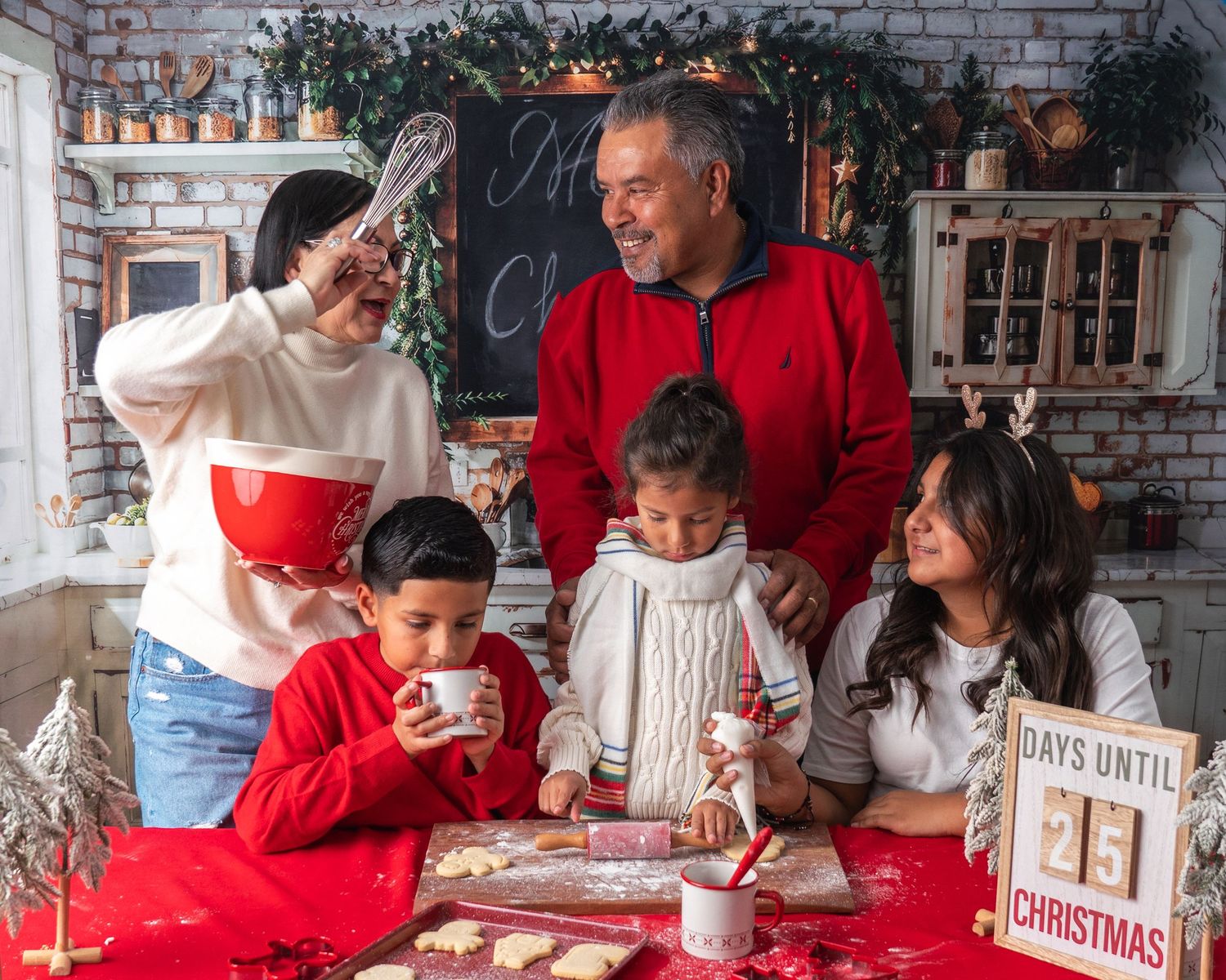 Family gathered around a rustic Christmas holiday display with countdown sign and festive red and white decorations.