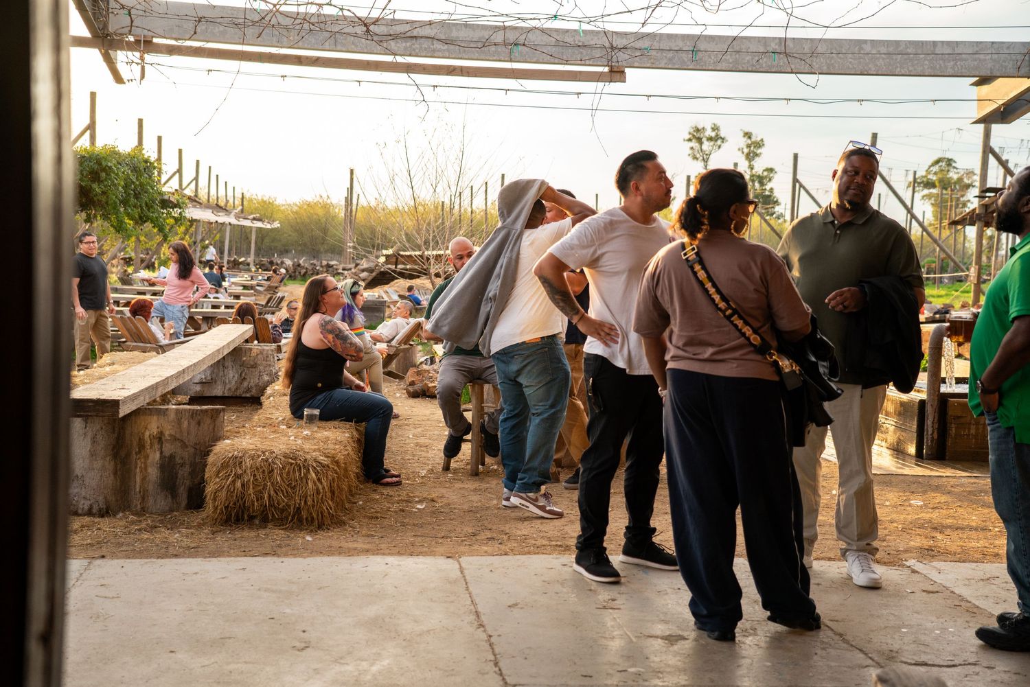 Visitors explore outdoor farm market with hay bales at a California agricultural event.