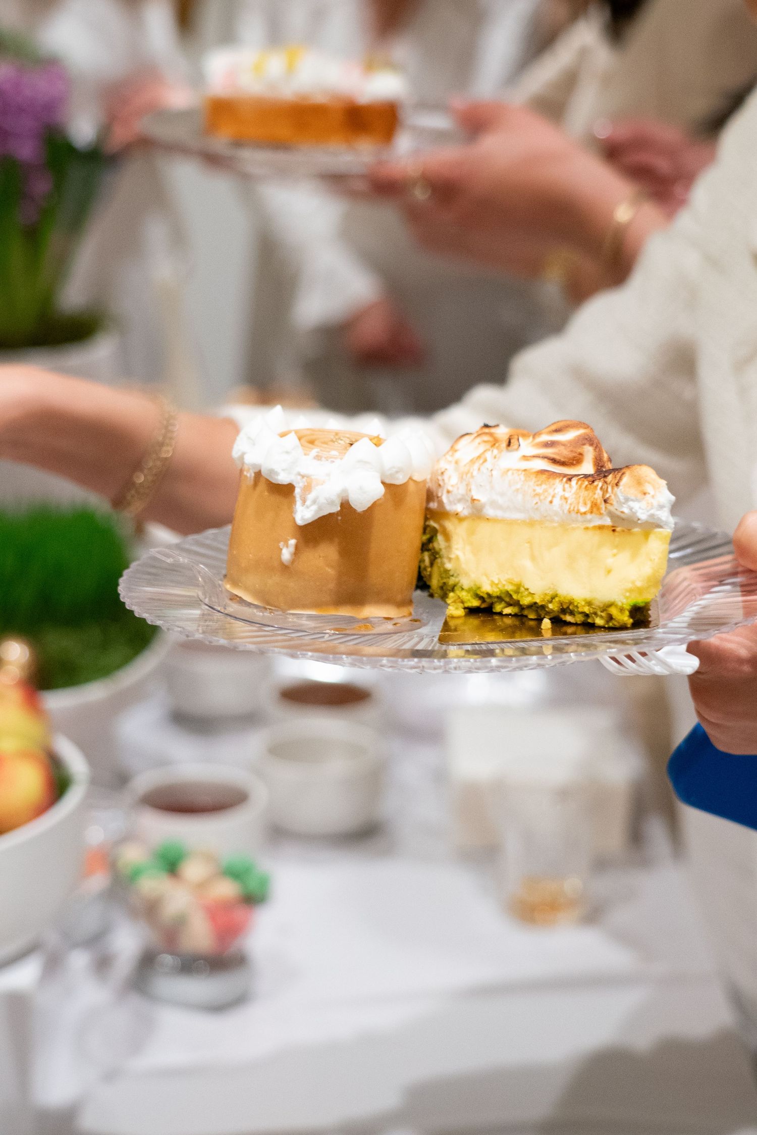 Various desserts being served on crystal plates at an elegant event.