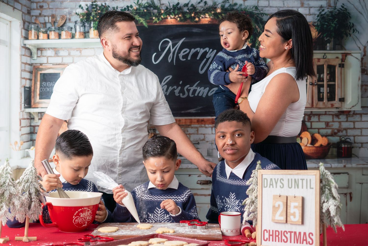 Family enjoying holiday baking and cookie decorating around a rustic kitchen table with Christmas decor.