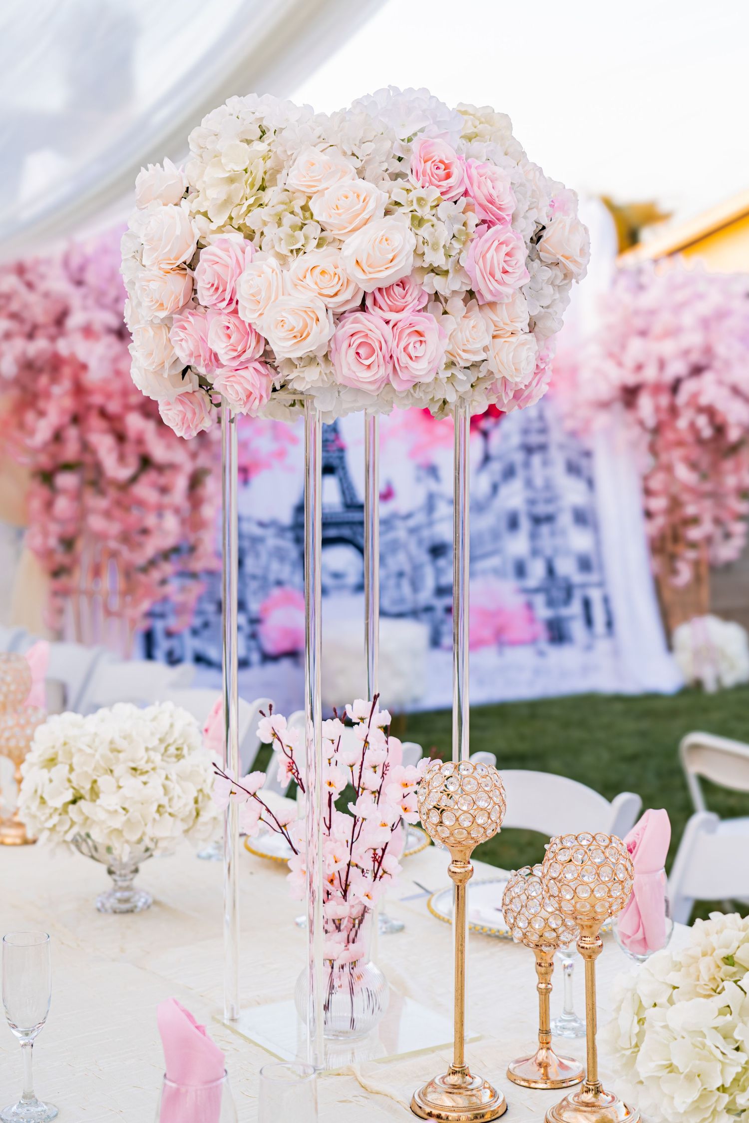 Luxurious wedding table setting with tall floral centerpieces featuring pink and white roses.