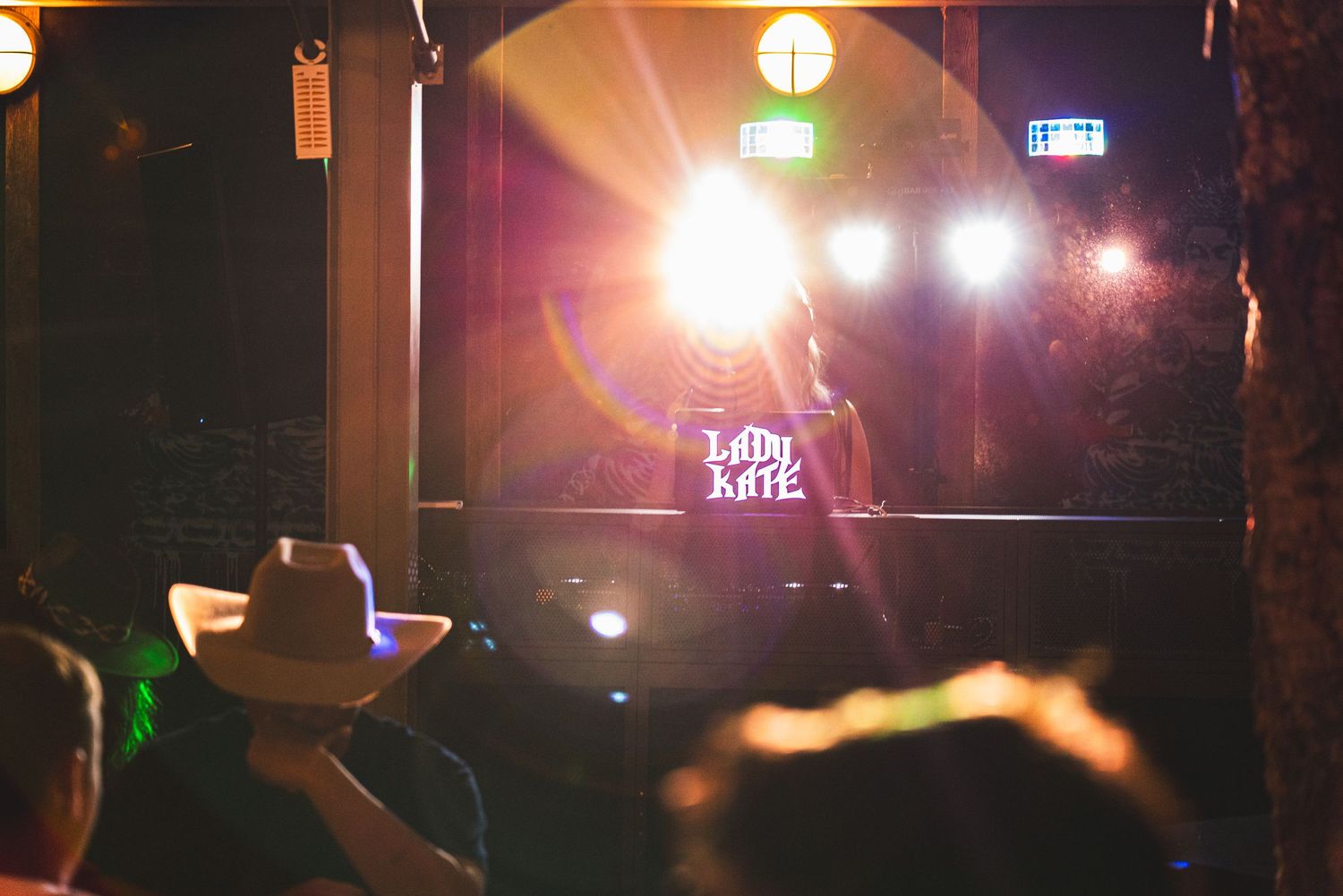 Lady Kate performs on a bright stage at a live music venue with an audience in the foreground.