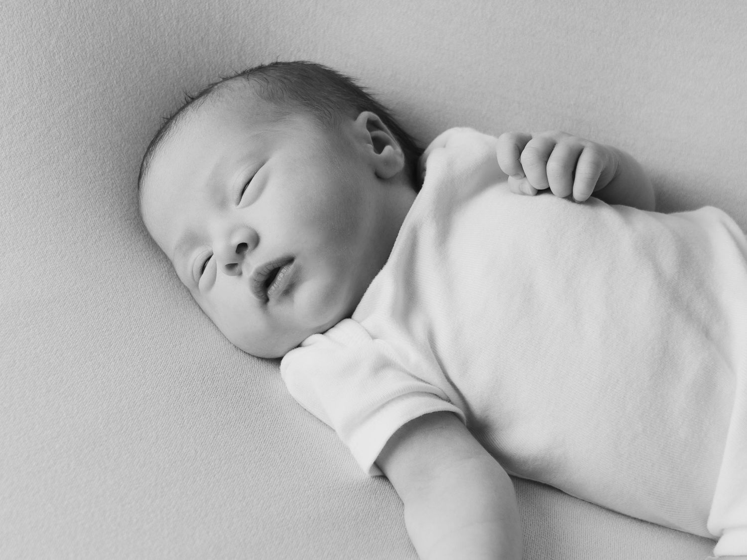 Black and white profile of sleeping newborn in minimalist style.