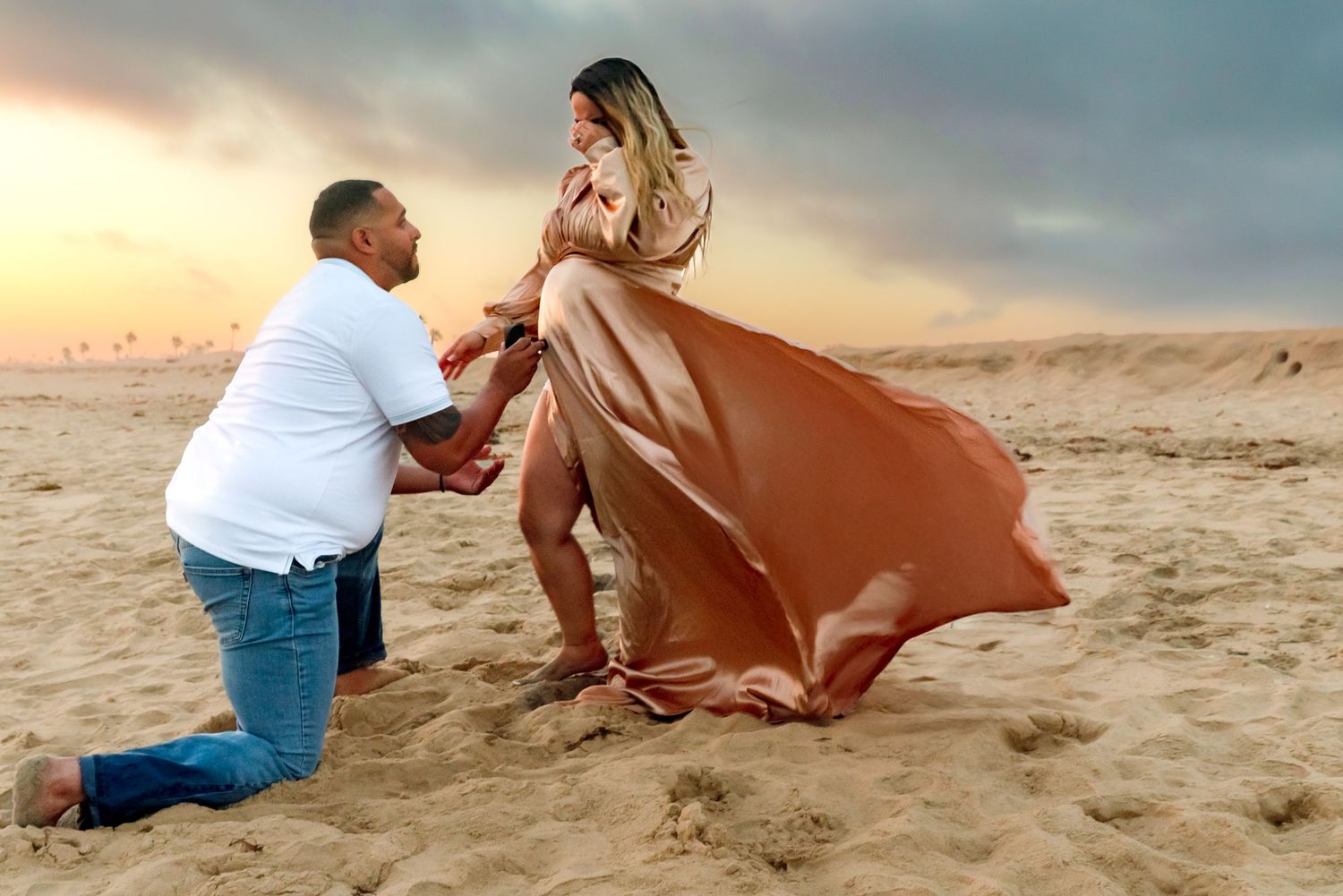 Romantic couple photoshoot at sunset on a sandy beach.