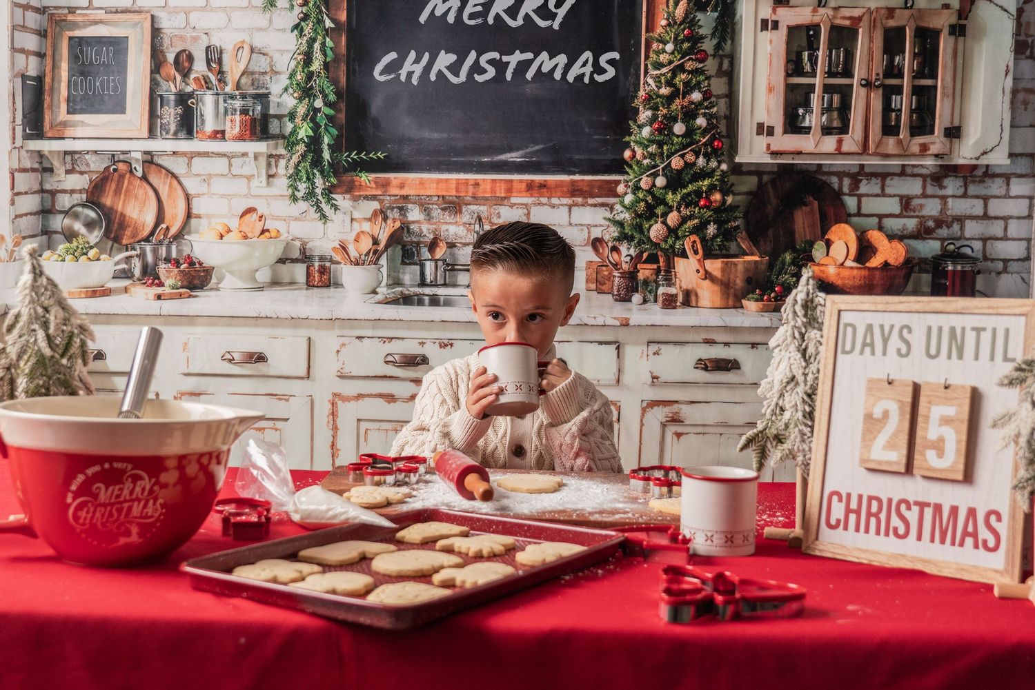 A festive Christmas table setting with red decor, cookies, and a chalkboard sign in a rustic kitchen interior.