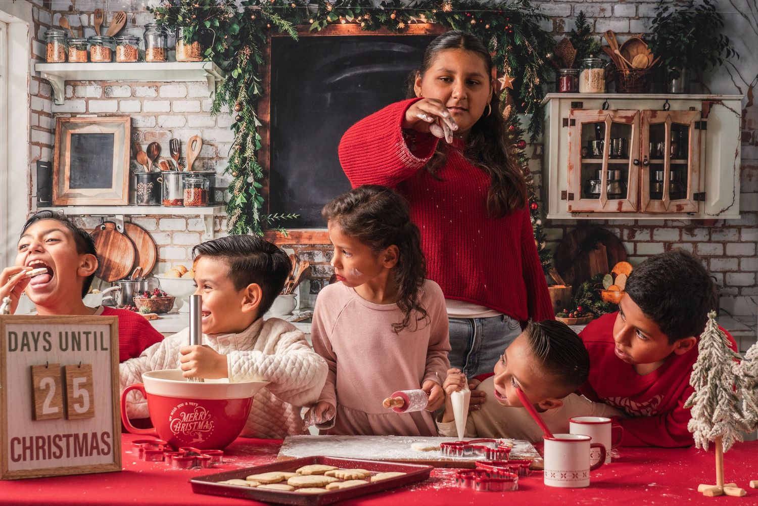 Cozy Christmas gathering with countdown sign and family members enjoying hot drinks in red and white attire.