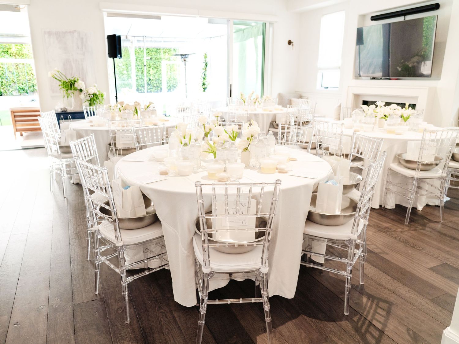 Elegant white dining room setup with round tables and chairs for a formal event.