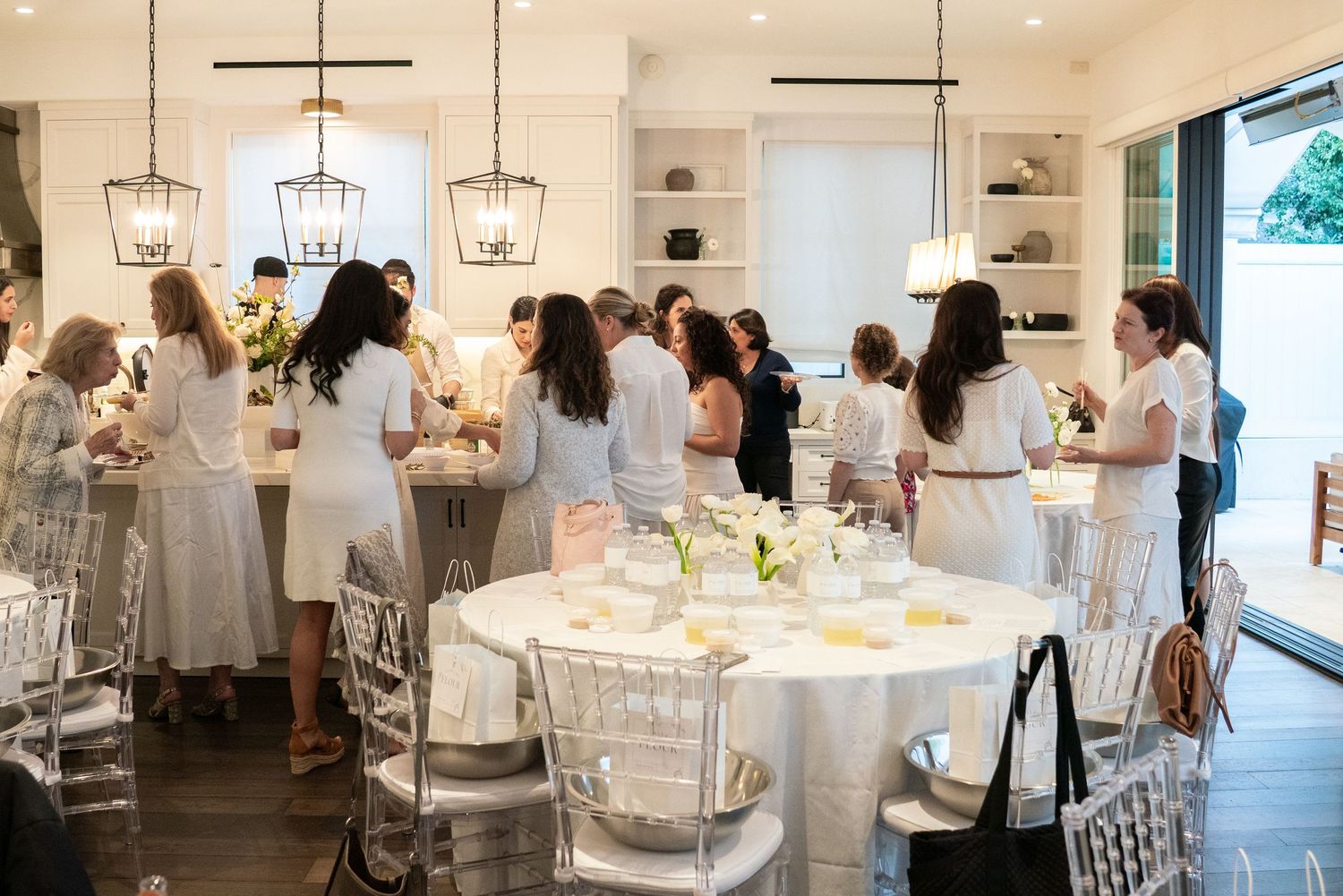 Bright modern reception space with pendant lights and guests seated at round tables.
