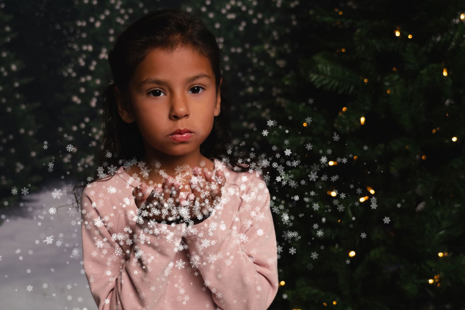 A person wearing a pink dress poses against a dark background with glittering sparkles and bokeh lights.