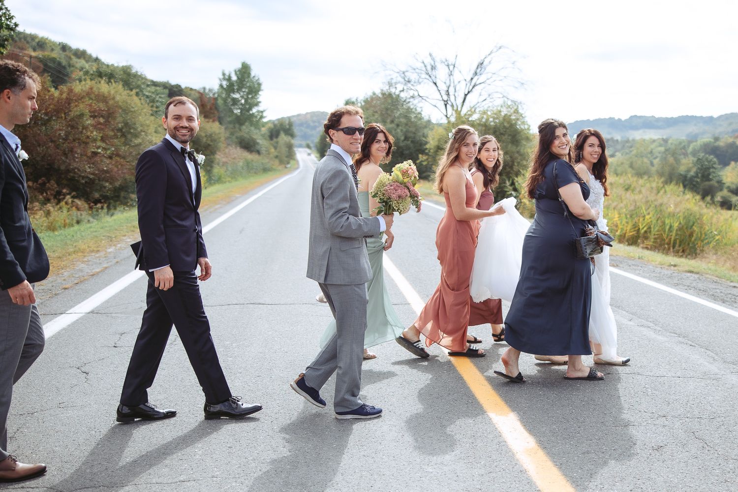 Membres du cortège de mariage réalisant une danse synchronisée amusante sur une route rurale, en Estrie