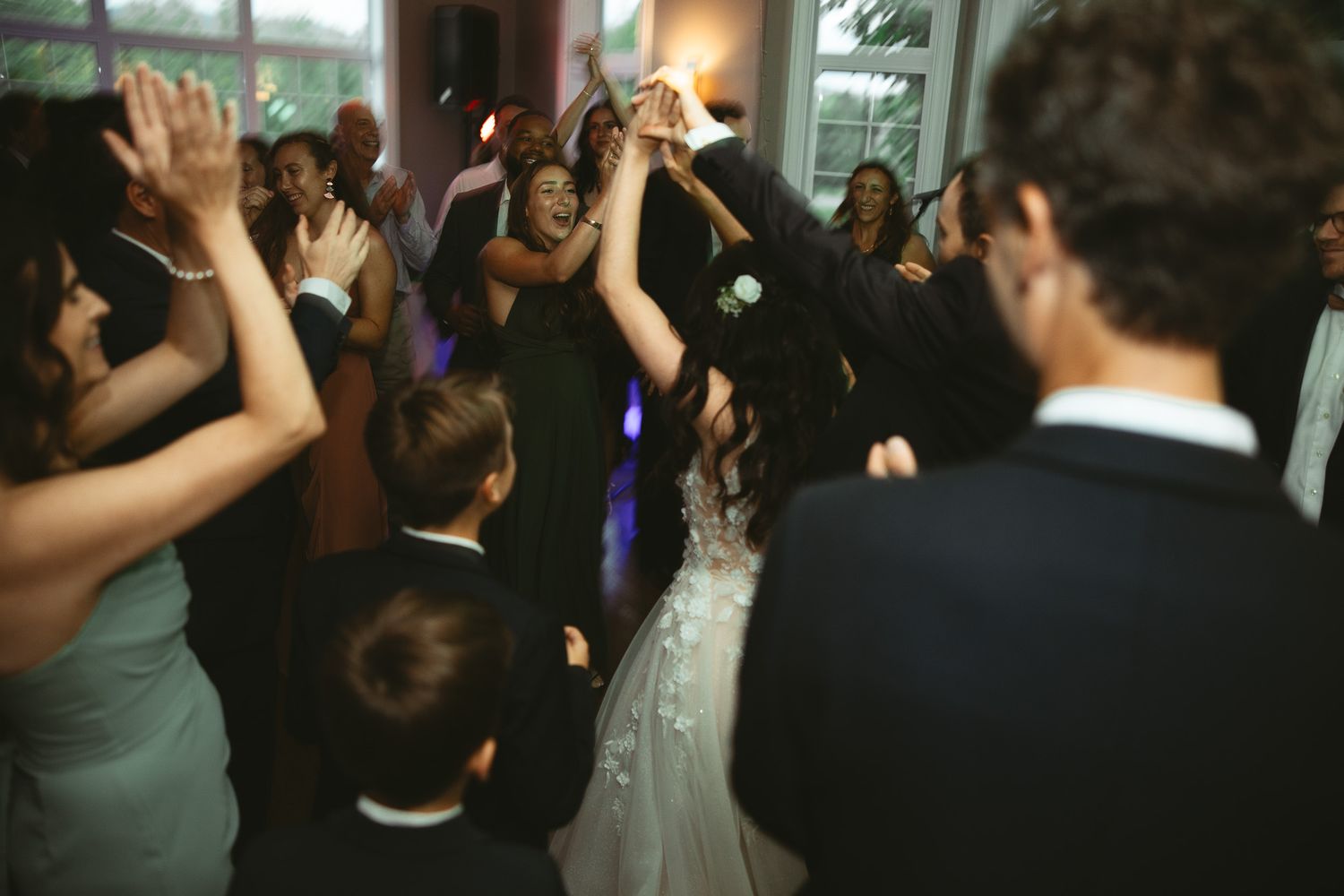 Piste de danse de réception de mariage animée par les invités célébrant dans une salle à l’éclairage tamisé à Bromont