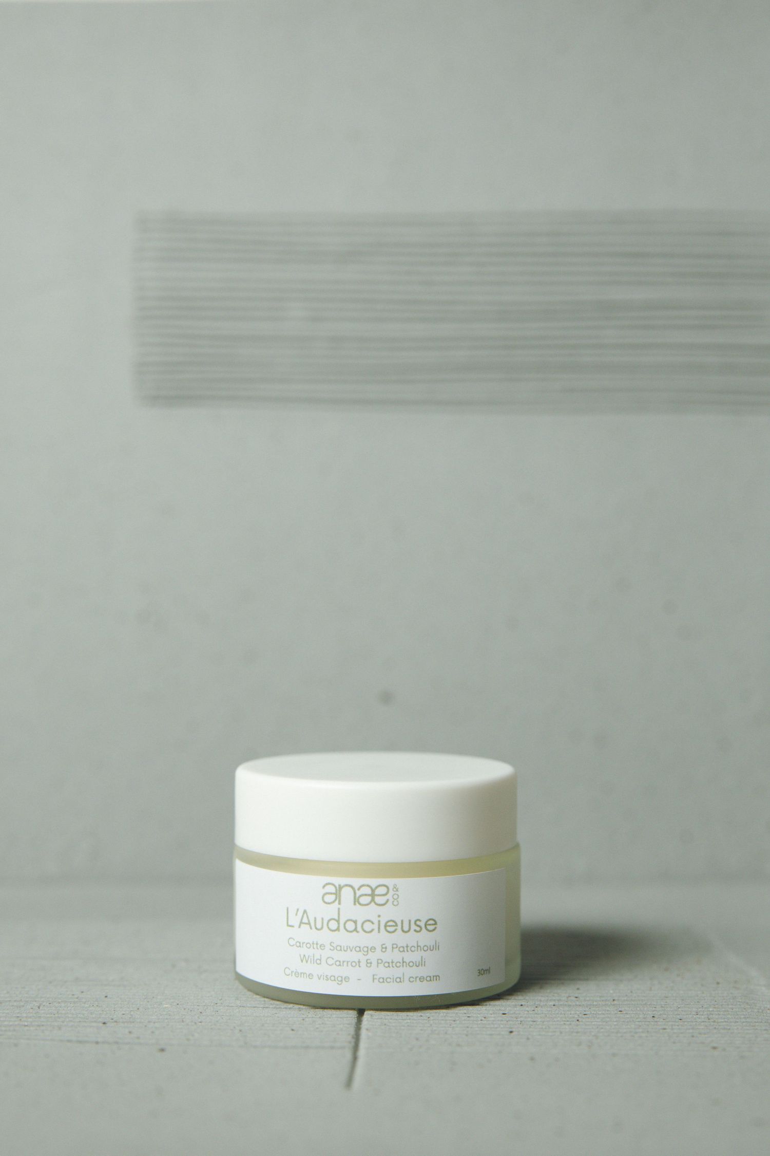 White cosmetic cream jar product photography on light gray background.