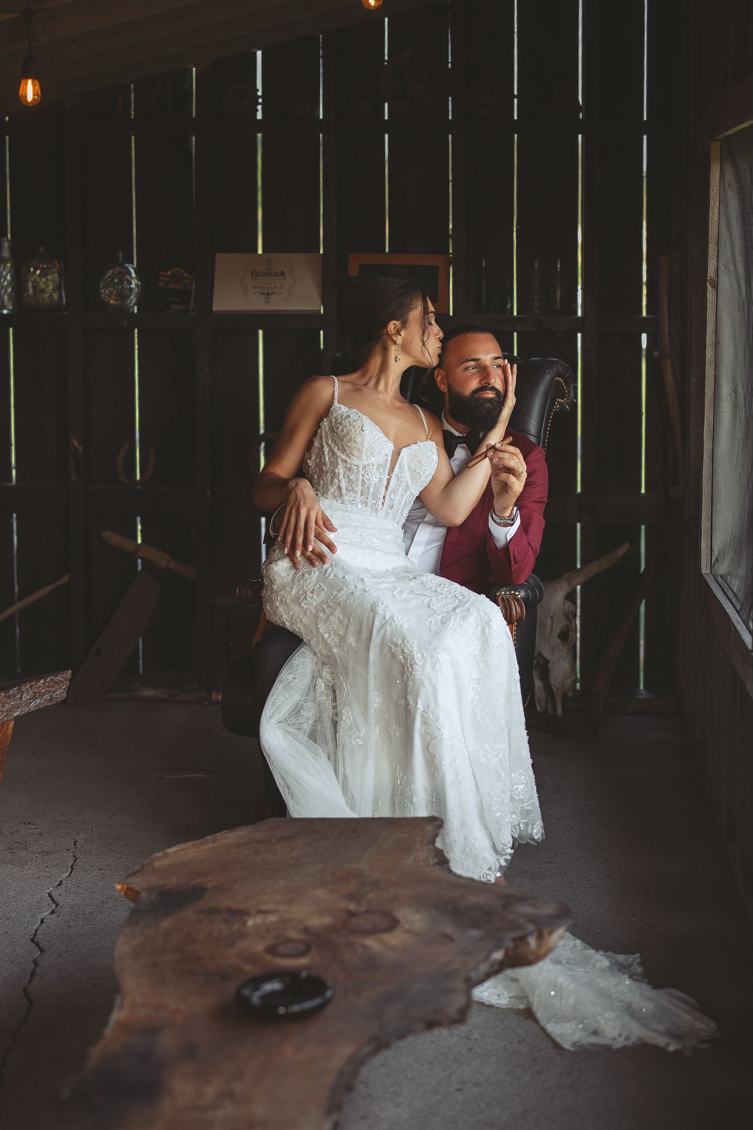 Couple de mariés partageant une danse intime dans une cigar lounge, sublimée par une lumière dramatique lors de la réception.