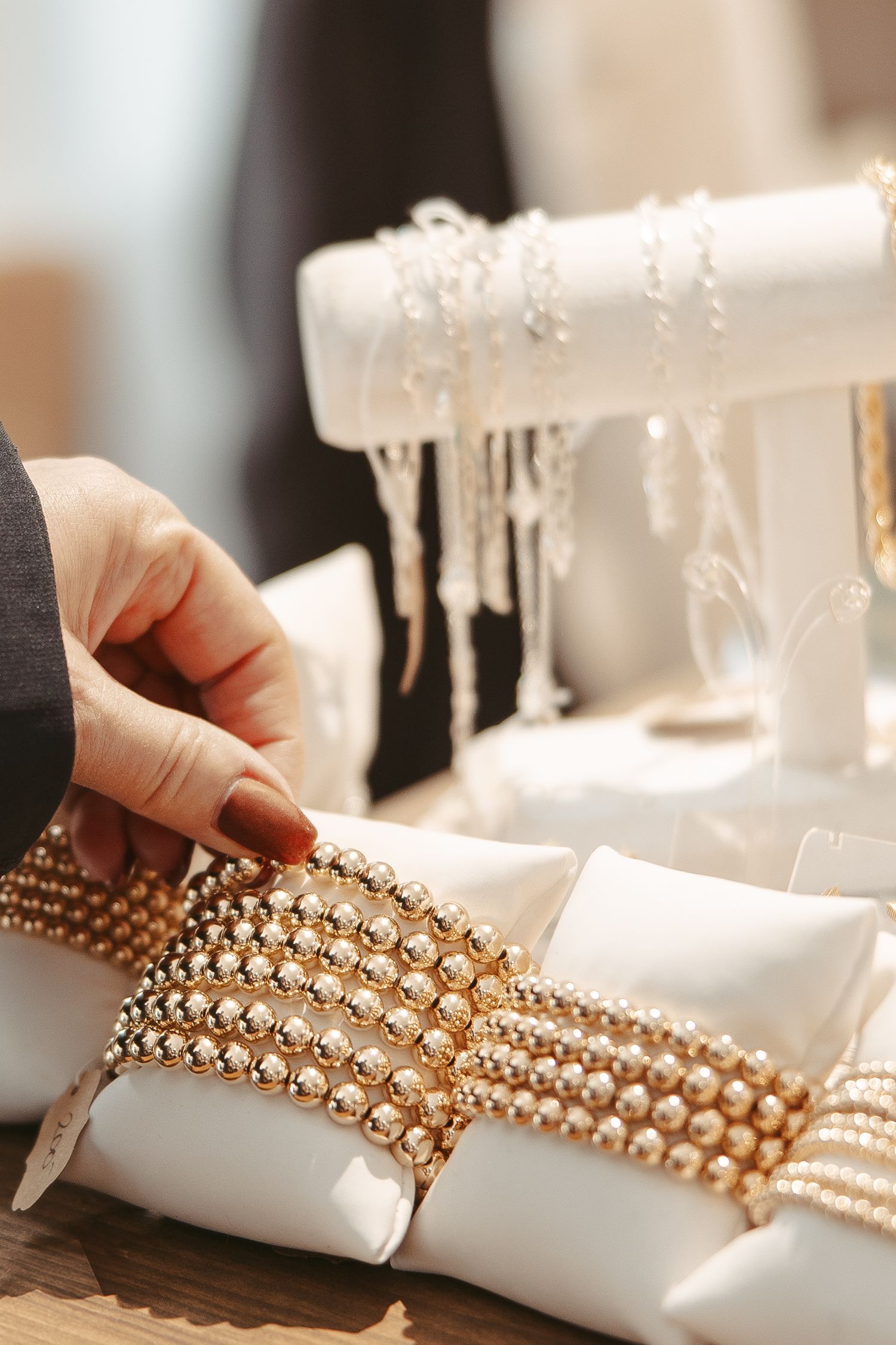 Pearl and crystal headpiece being arranged on a white display pillow.