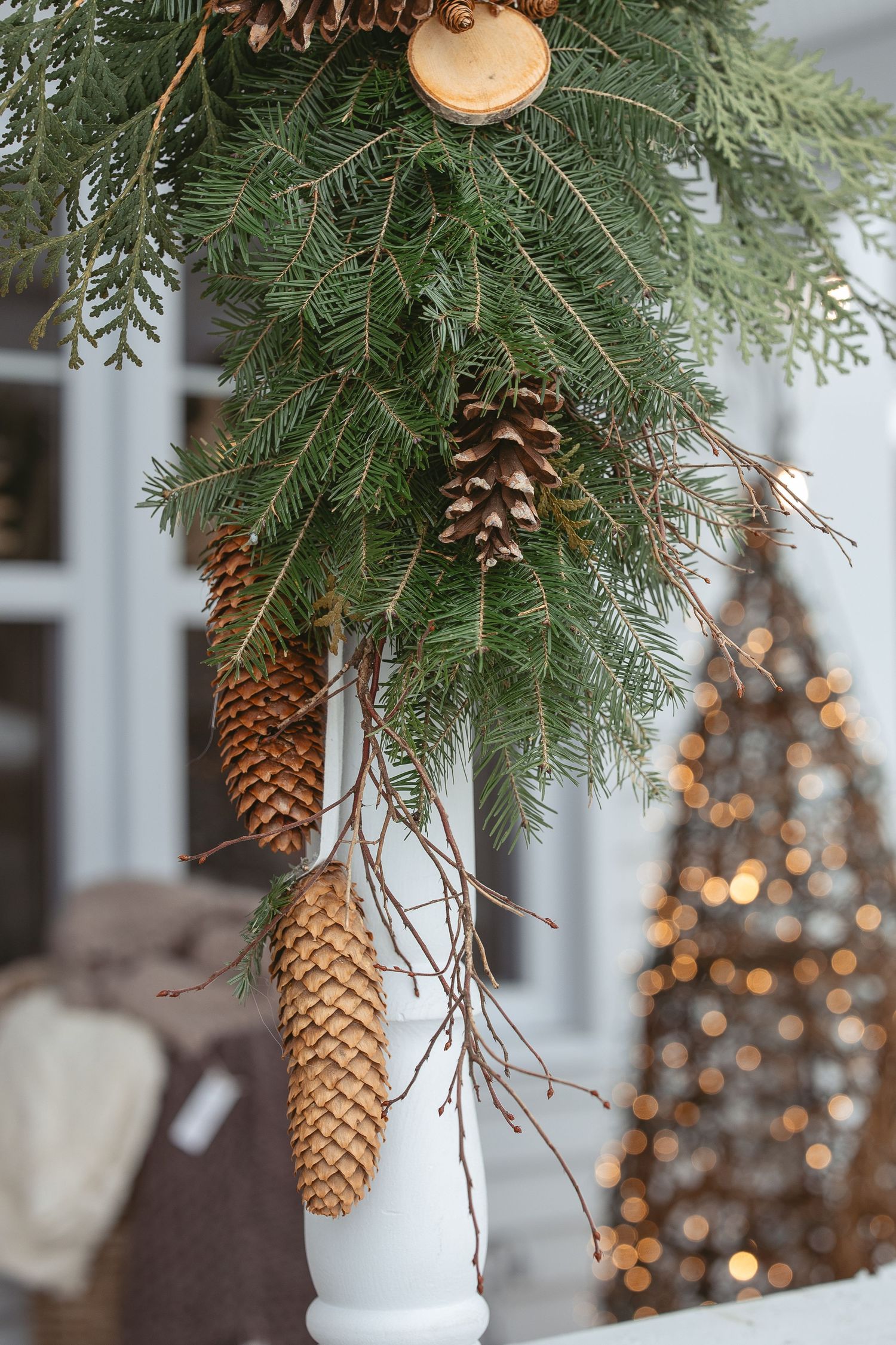 Fresh pine branches with natural pinecones and twinkling lights creating festive holiday decor.