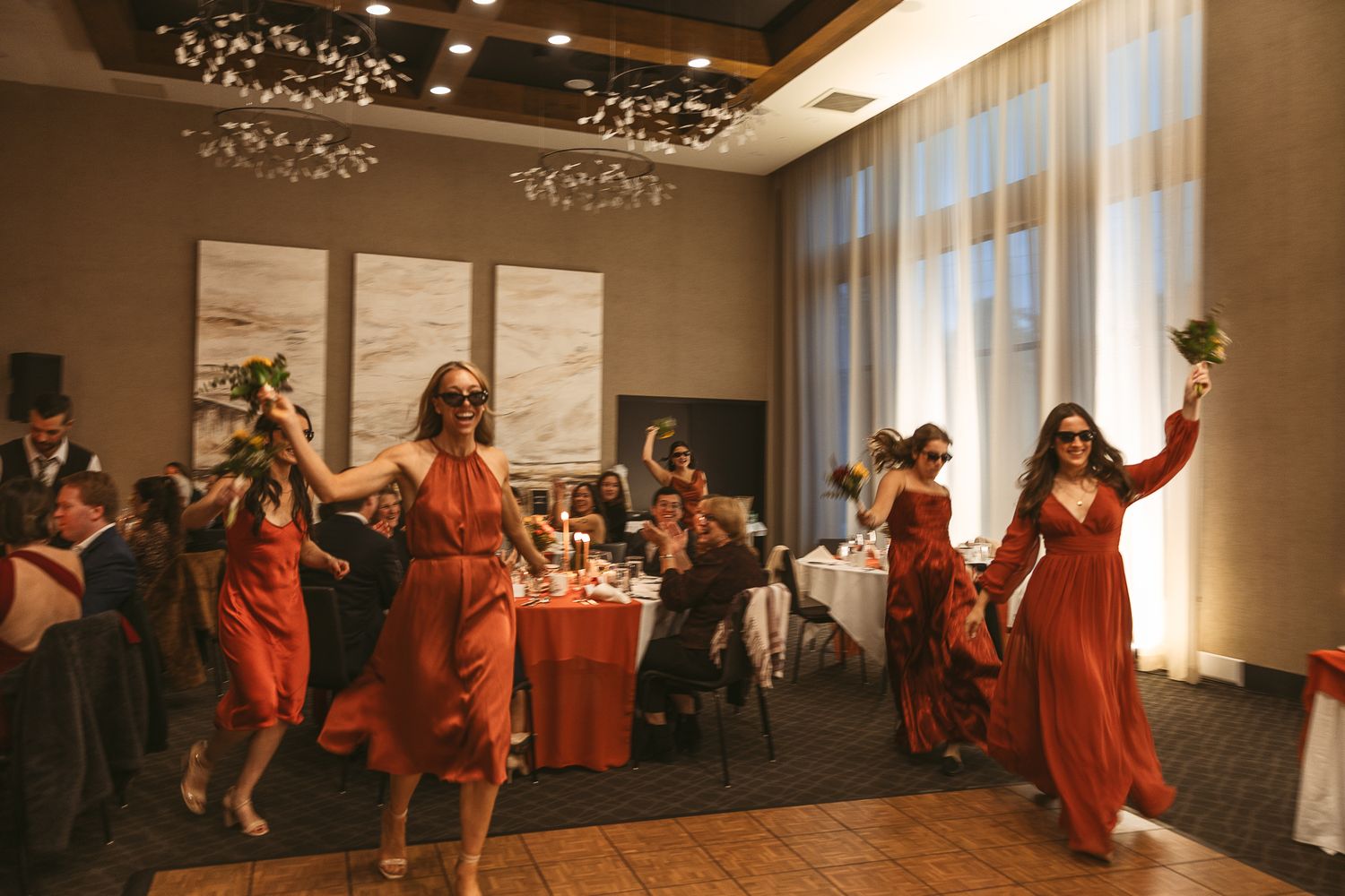Le cortège de mariage danse de façon synchronisée, vêtu de robes rouges et de complets, lors d’un mariage à Espace Quatre Saison, Orford.