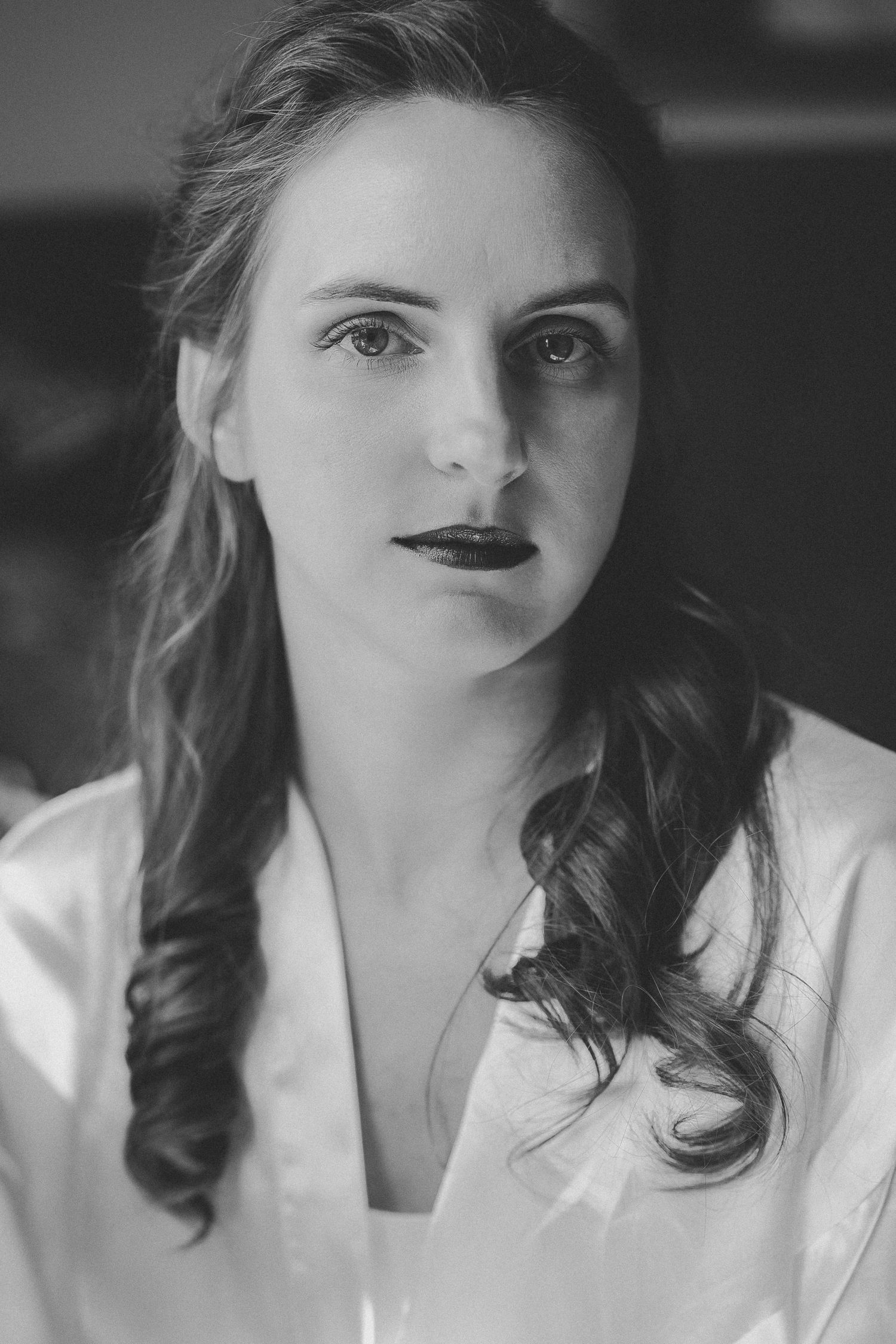 Black and white portrait series showing dramatic lighting and dark lipstick against a white background.