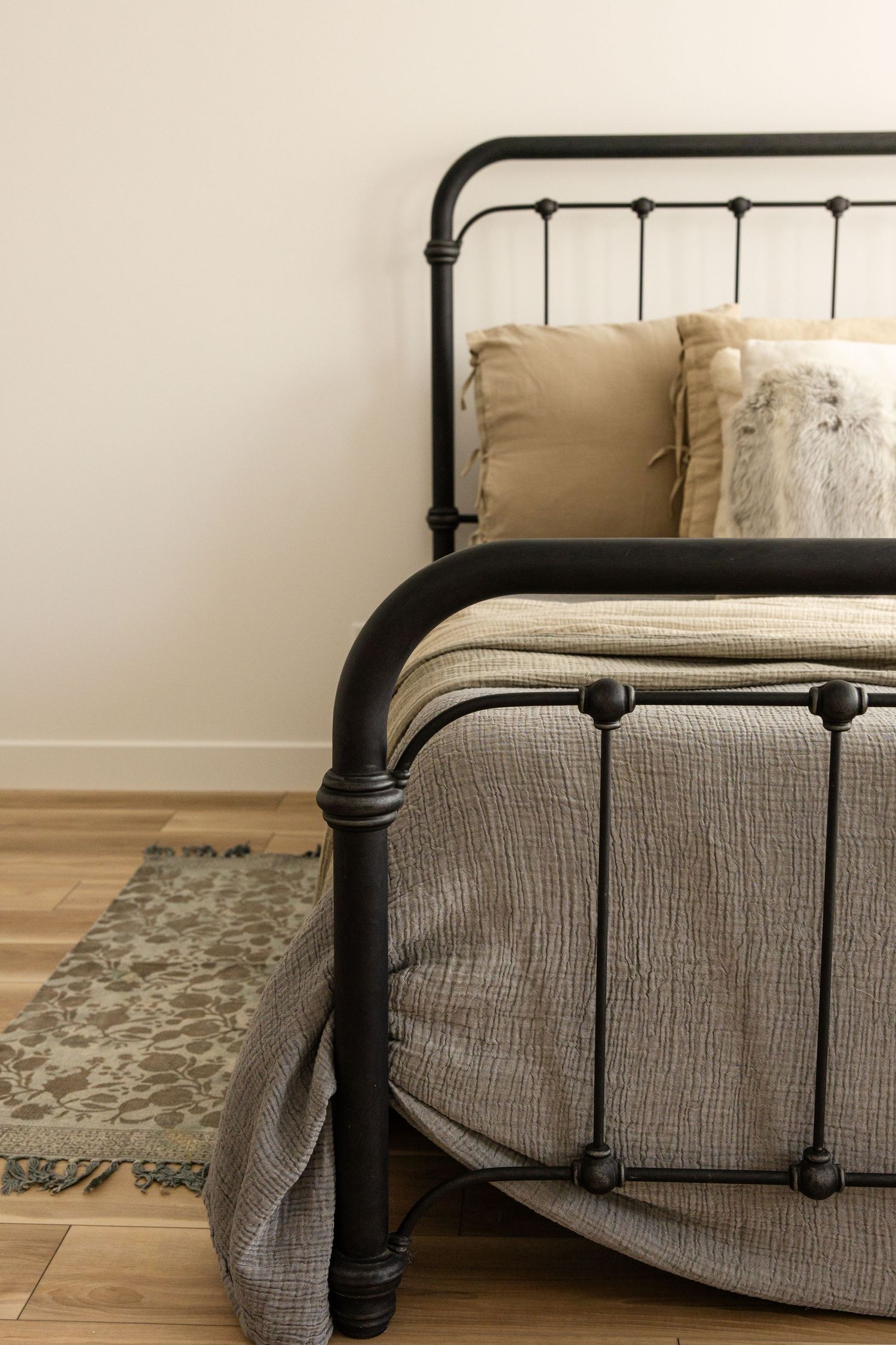Black metal bed frame with grey upholstered headboard and footboard shown from multiple angles on hardwood floor.