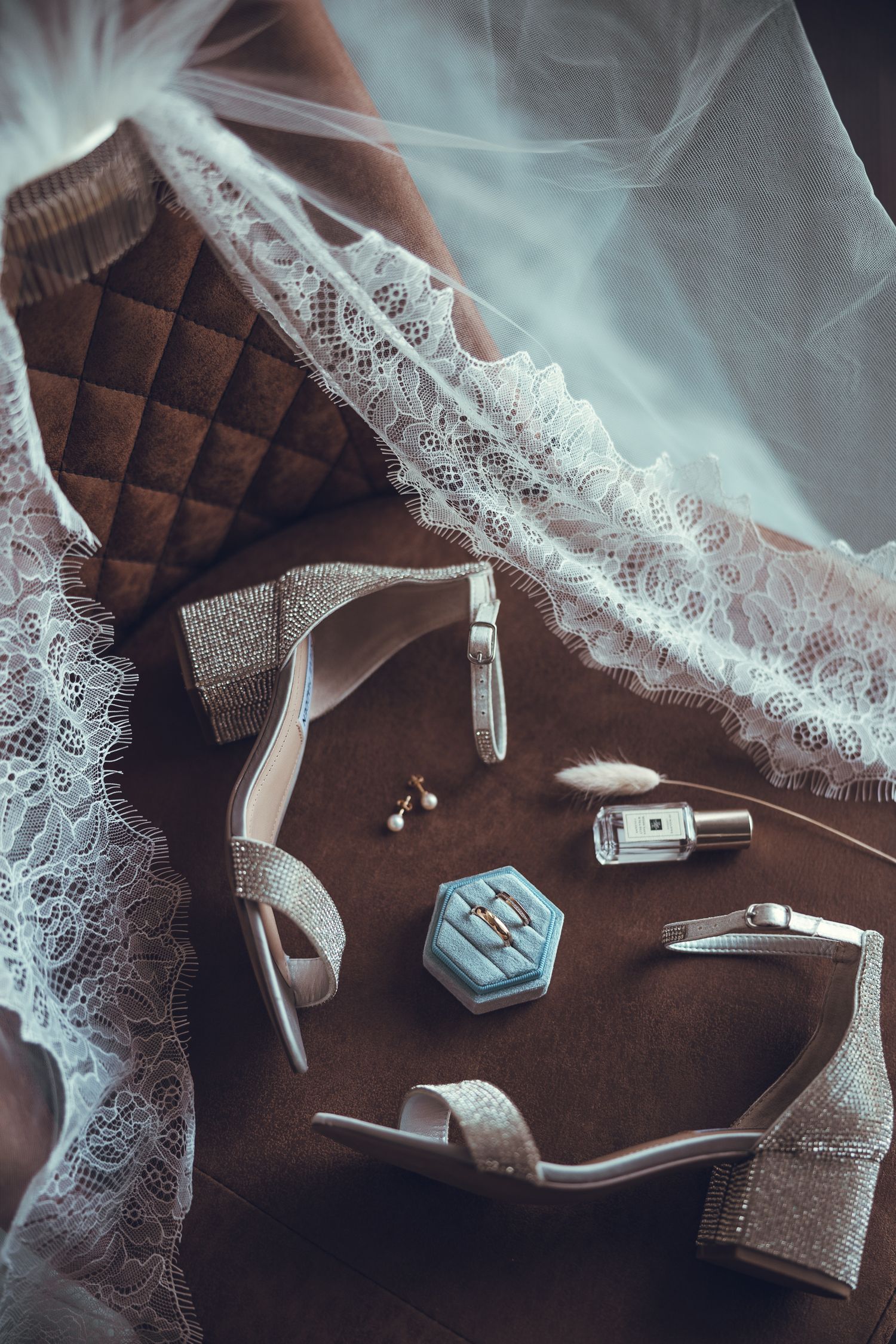 Dentelle blanche et tissu brun chocolat composent une scène élégante, ponctuée de détails décoratifs sur fond sombre.