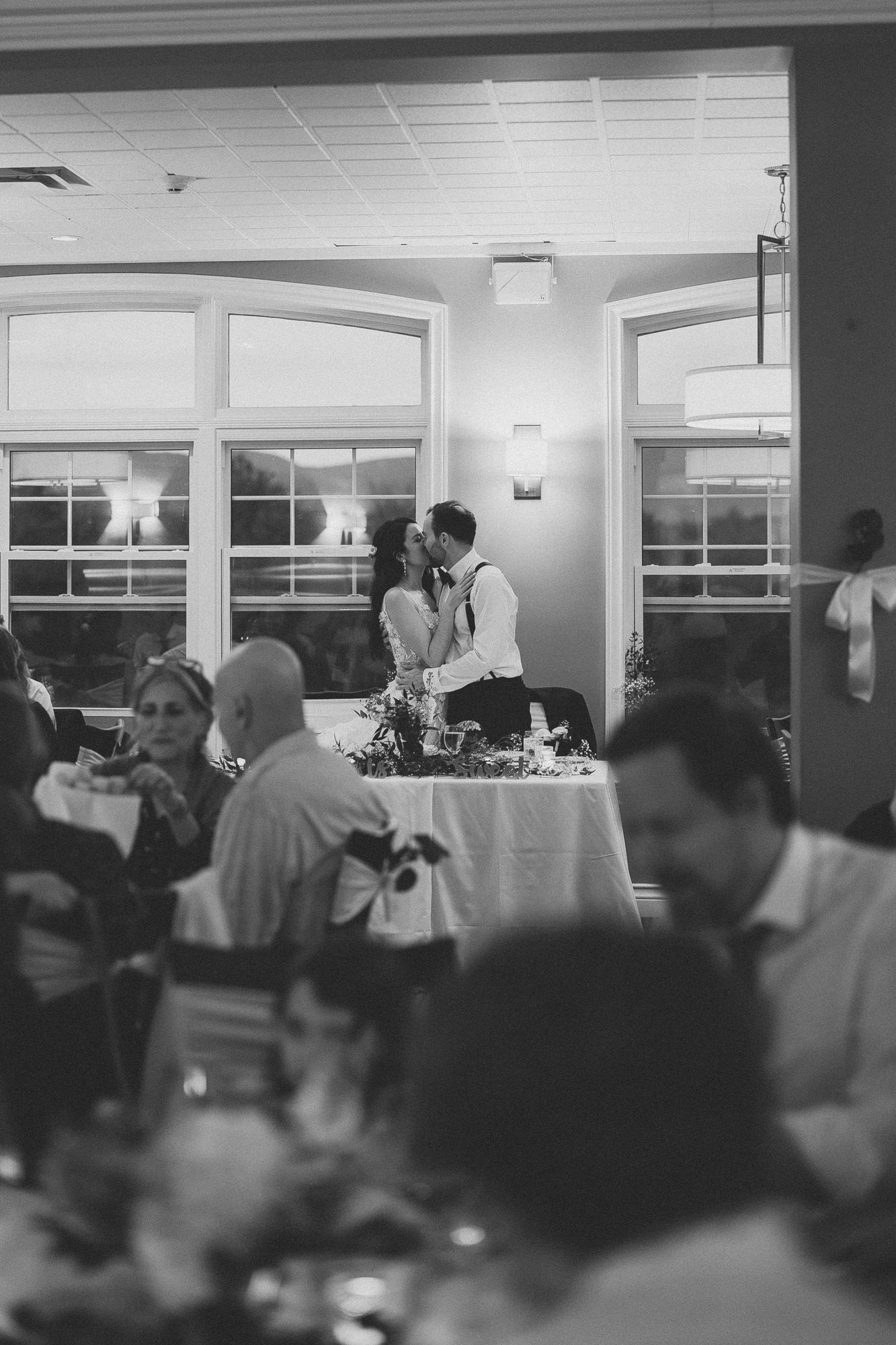 Vue panoramique en noir et blanc d’un lieu de réception de mariage rempli d’invités