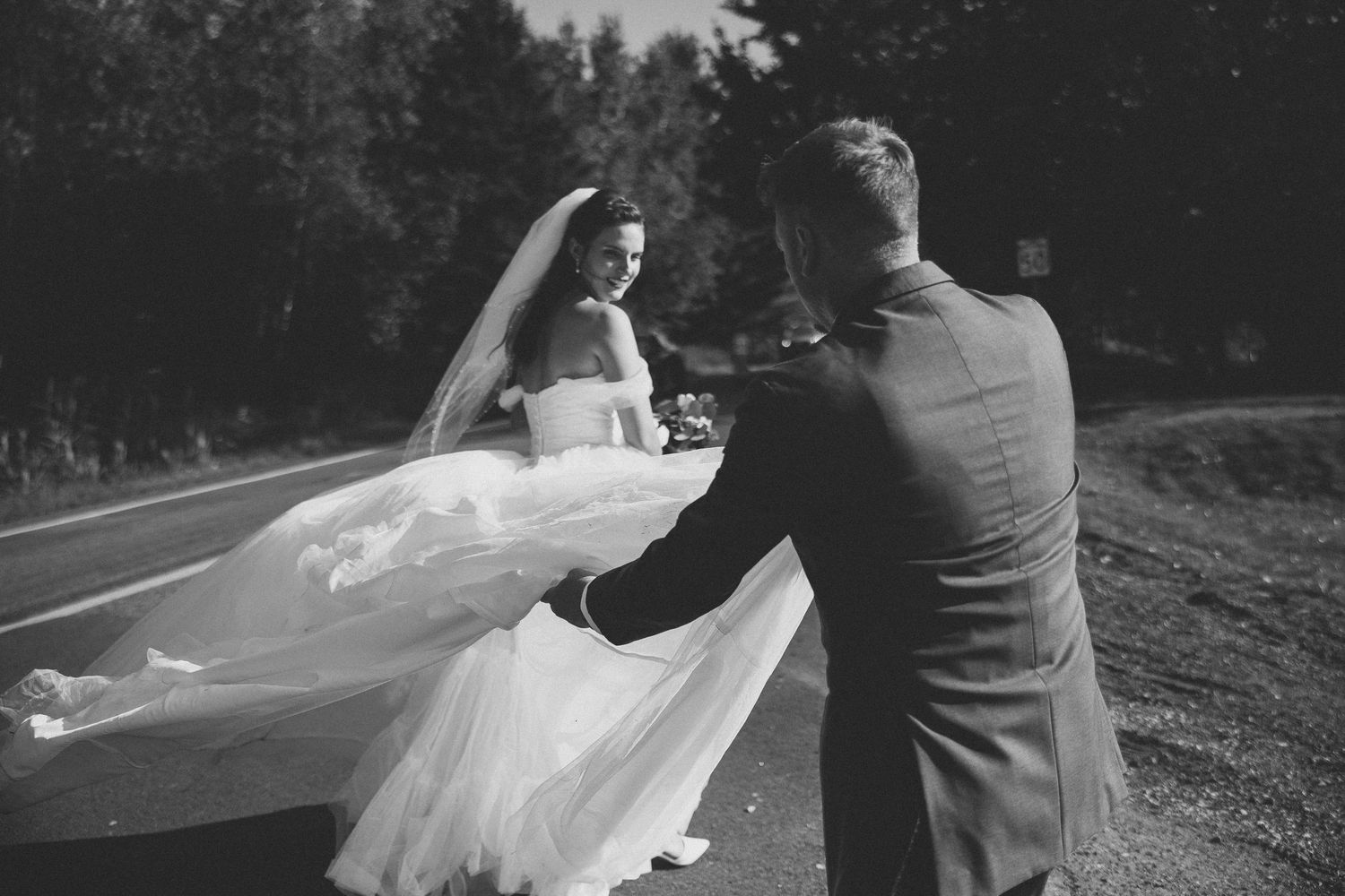 Black and white photo sequence of a bride's veil flowing gracefully in the wind on a country road.