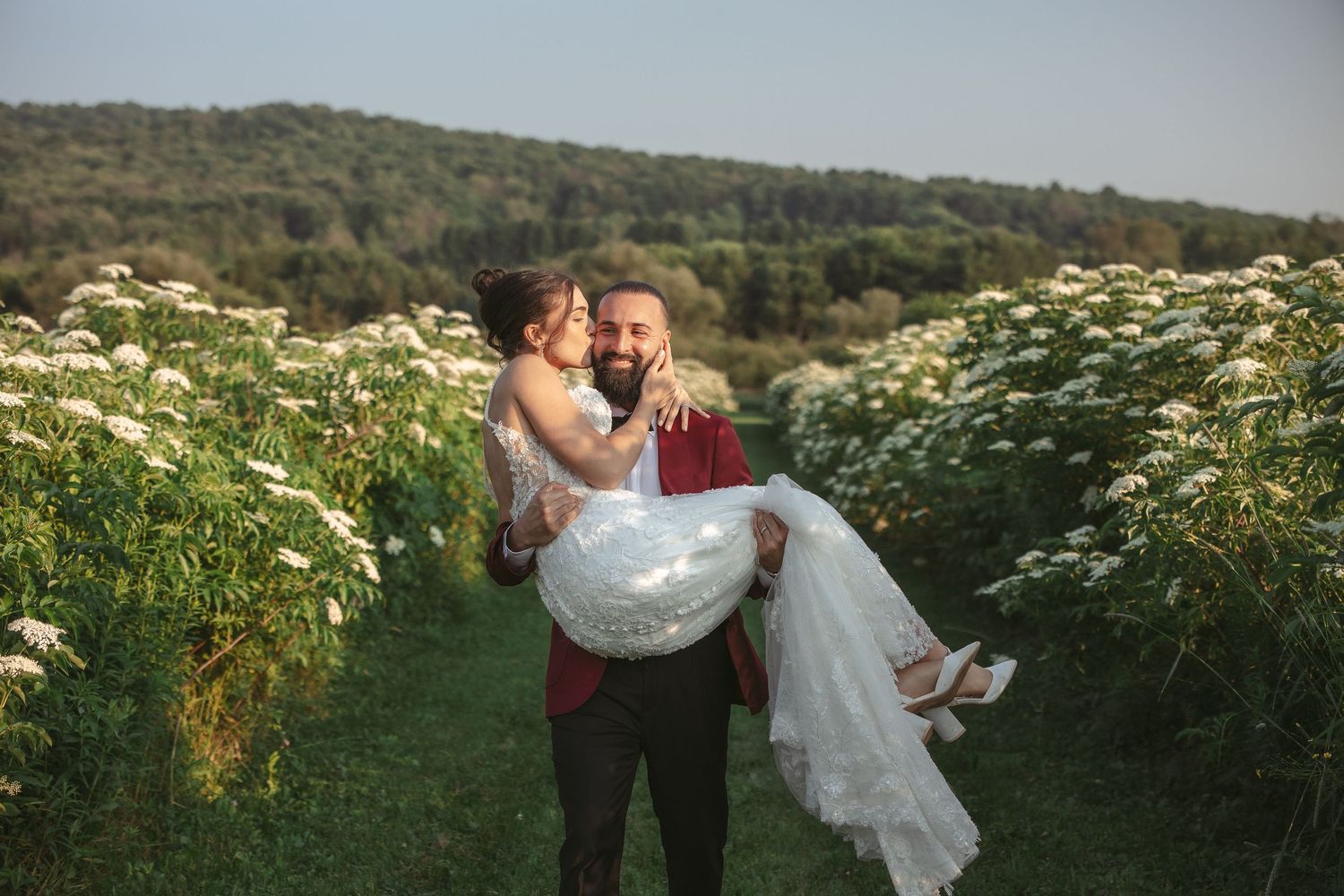 Couple embracing in a wildflower field during golden hour.