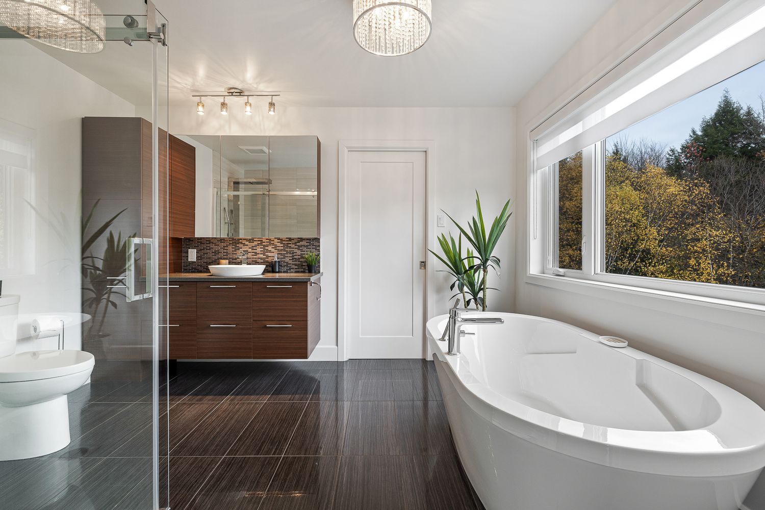 Salle de bain moderne avec grande fenêtre.  Photographie immobilière.
