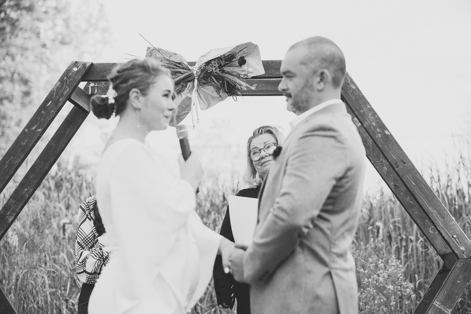 Cérémonie de mariage en plein air au cœur d’une forêt automnale, baignée d’une lumière dorée filtrant à travers les arbres.