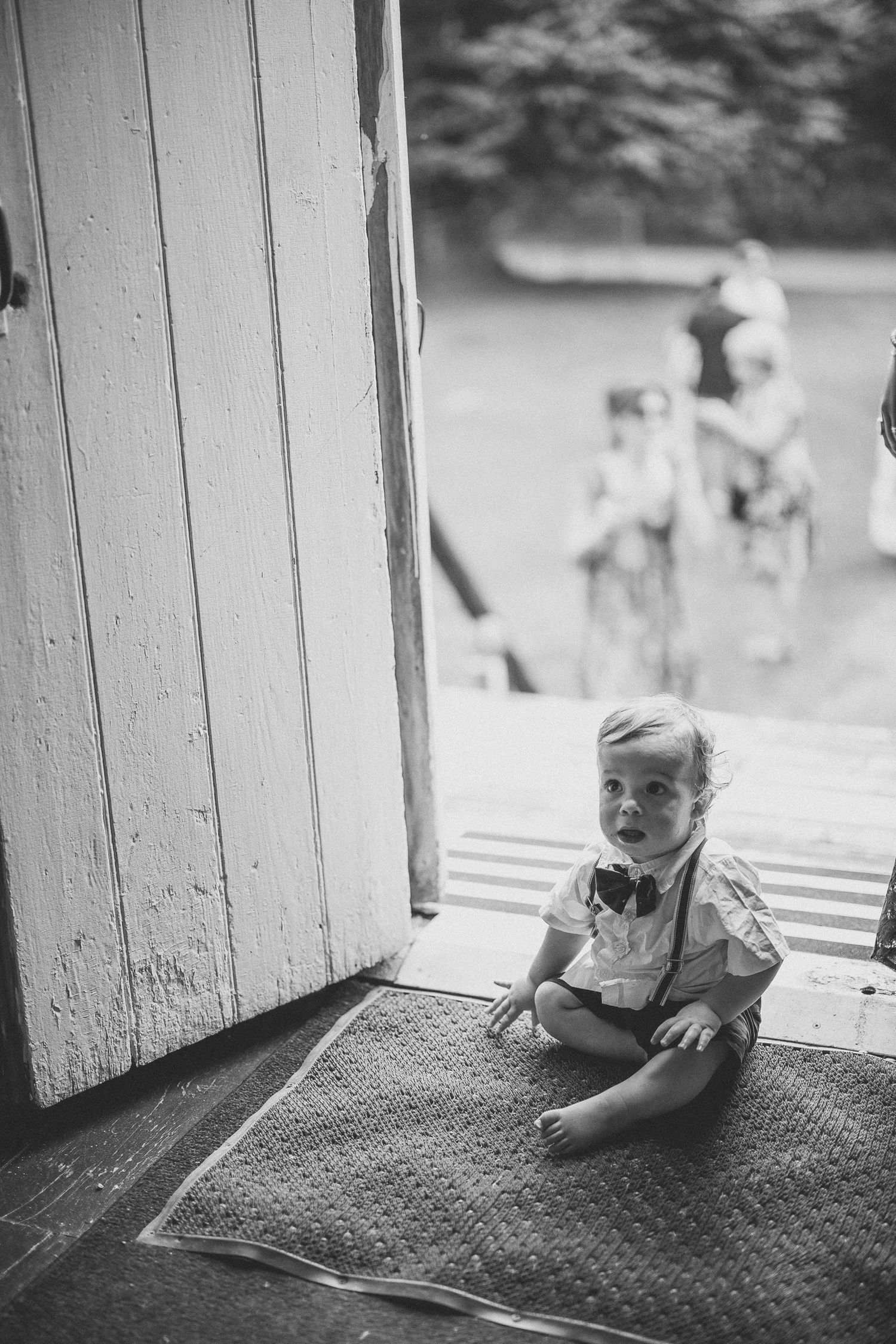 Bébé rampant sur un sol texturé, photographie en noir et blanc près d’un mur blanc