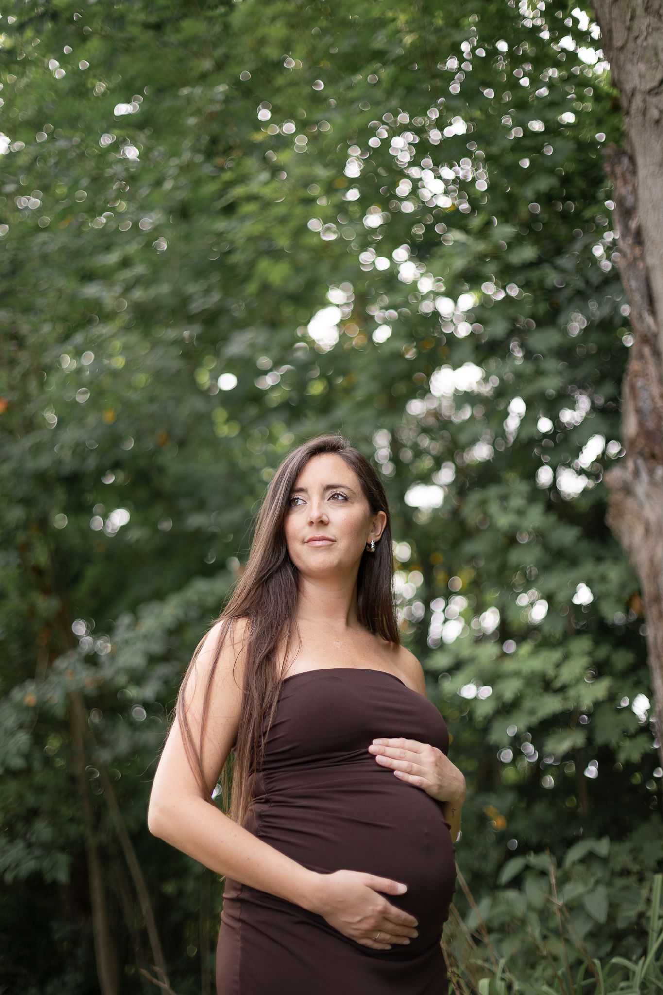 Séance maternité à Brigham : femme enceinte en robe brune dans cadre boisé, capturée pour élégance, tendresse et souvenirs chaleureux