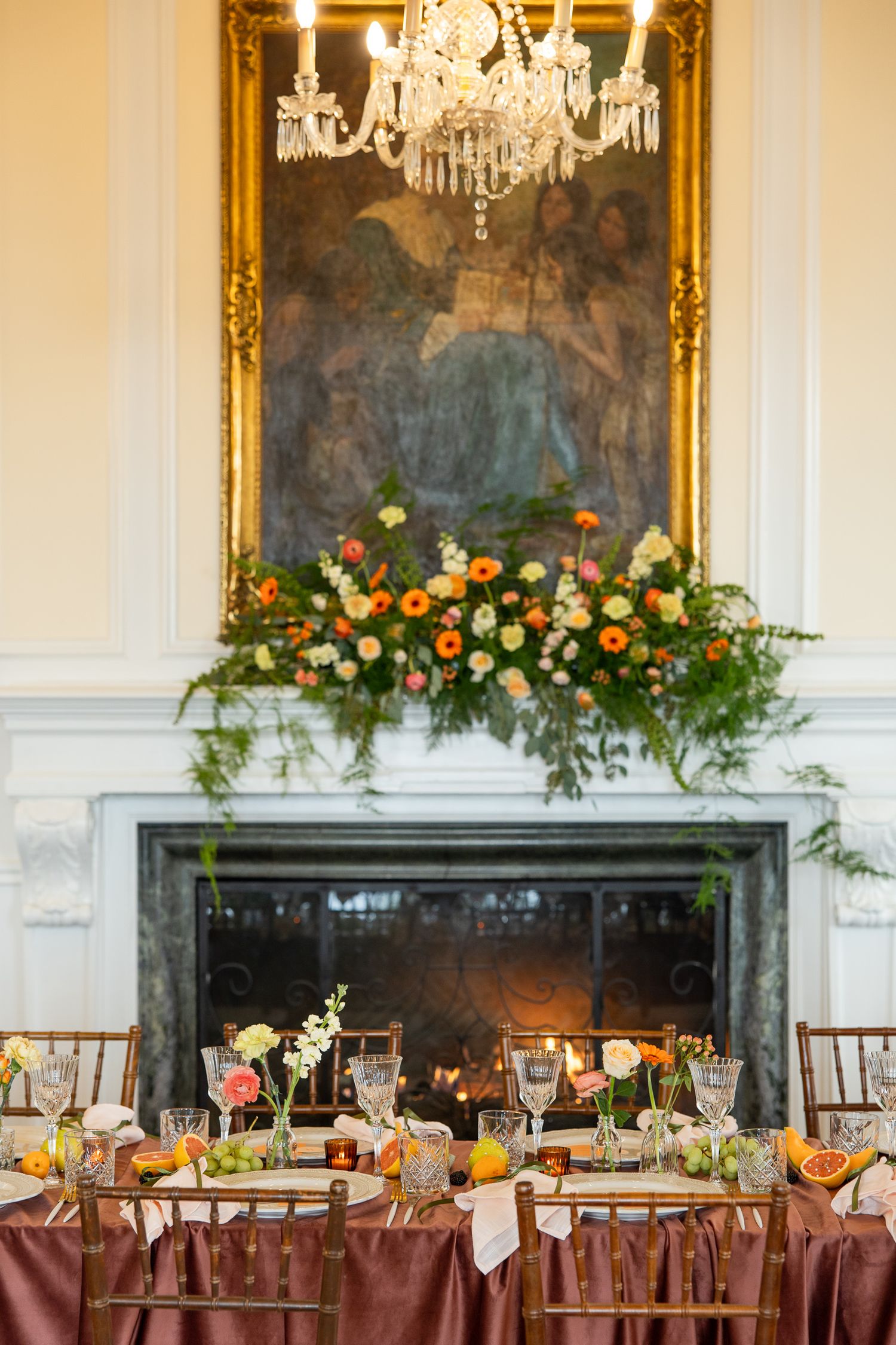 Des tables de banquet élégamment dressées pour une réception de mariage, avec des arrangements floraux et des lustres en cristal, dans une s
