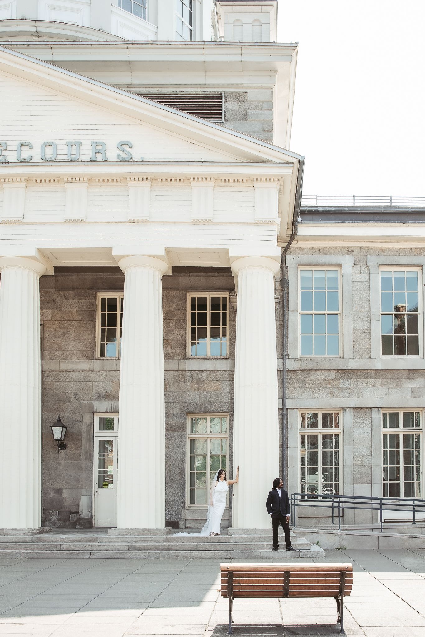 Mariés posés de façon éditorial devant le Marché Bonsecours dans le vieux Montréal.