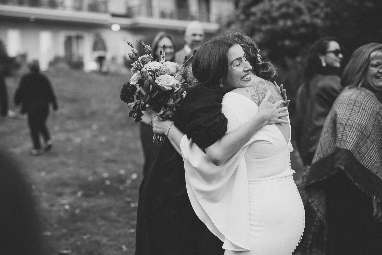 Black and white photo collage of joyful wedding moments showing dancing, embracing and celebration at an outdoor reception.