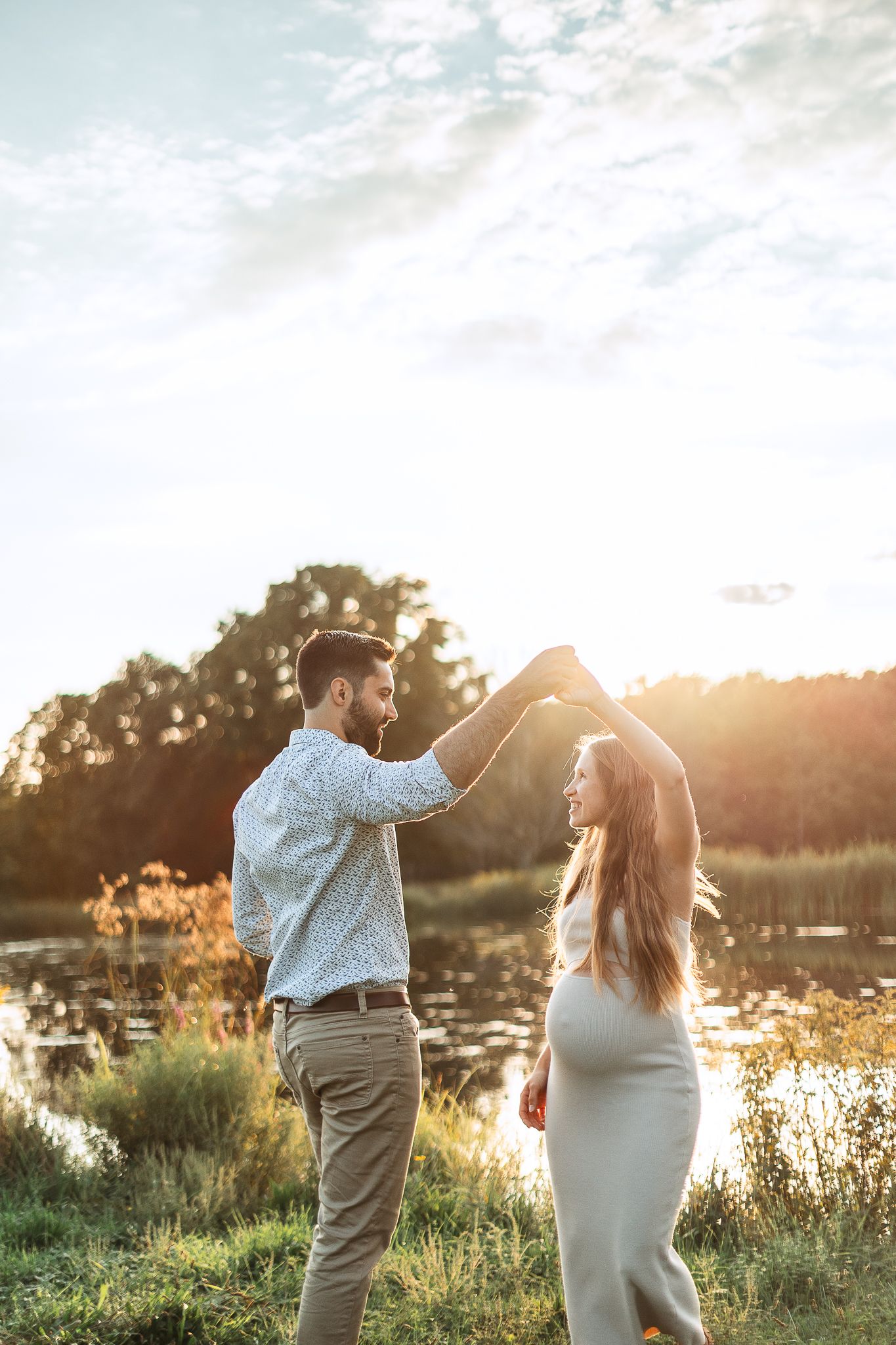 Couple dans champ doré à Bromont/Estrie au coucher du soleil près d’un lac, capturé pour moments romantiques et atmosphère magique