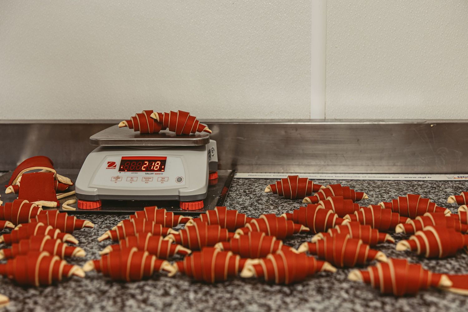 Rows of orange-colored pastries cooling on industrial baking racks.