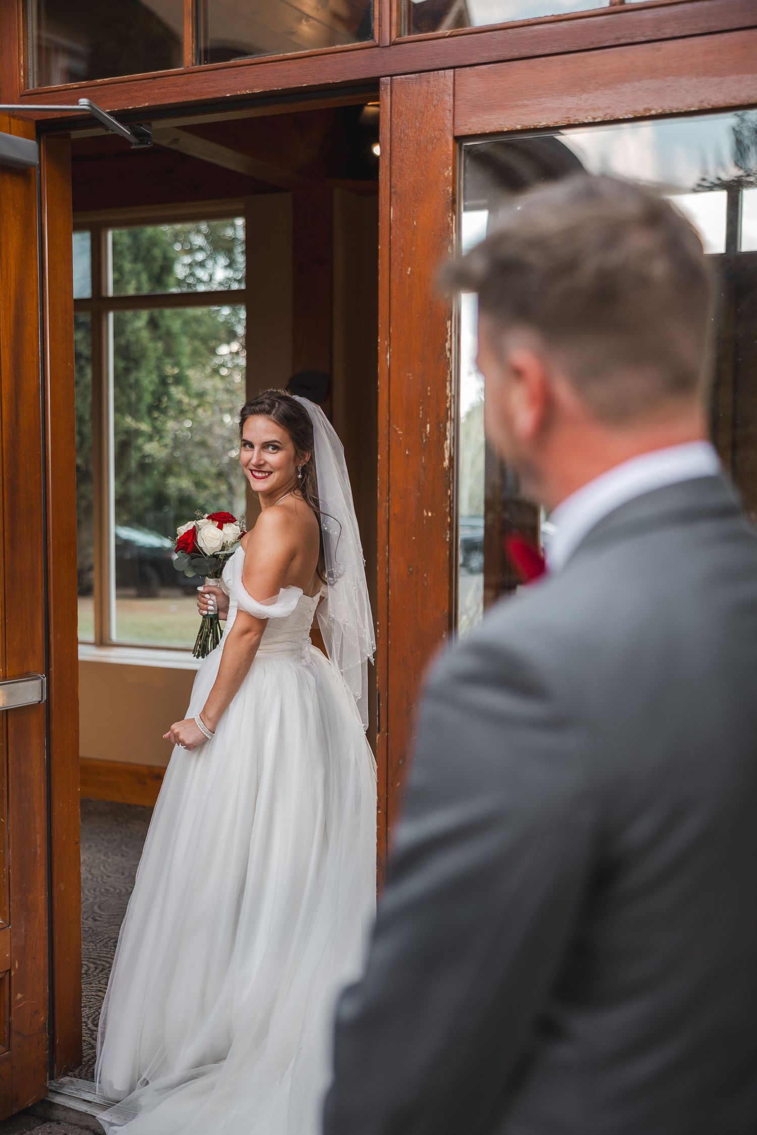 Wedding moment captured in rustic wooden interior with natural lighting.
